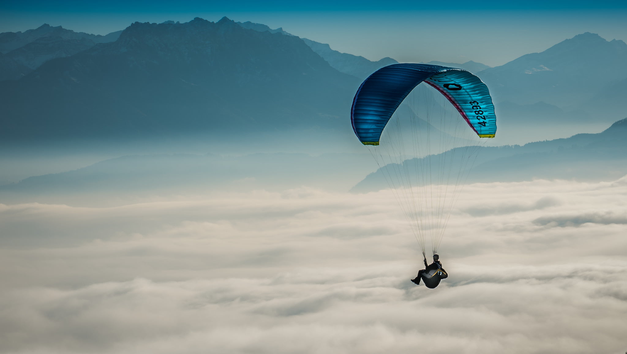 Person riding a para-glider flying over the clouds HD wallpaper ...
