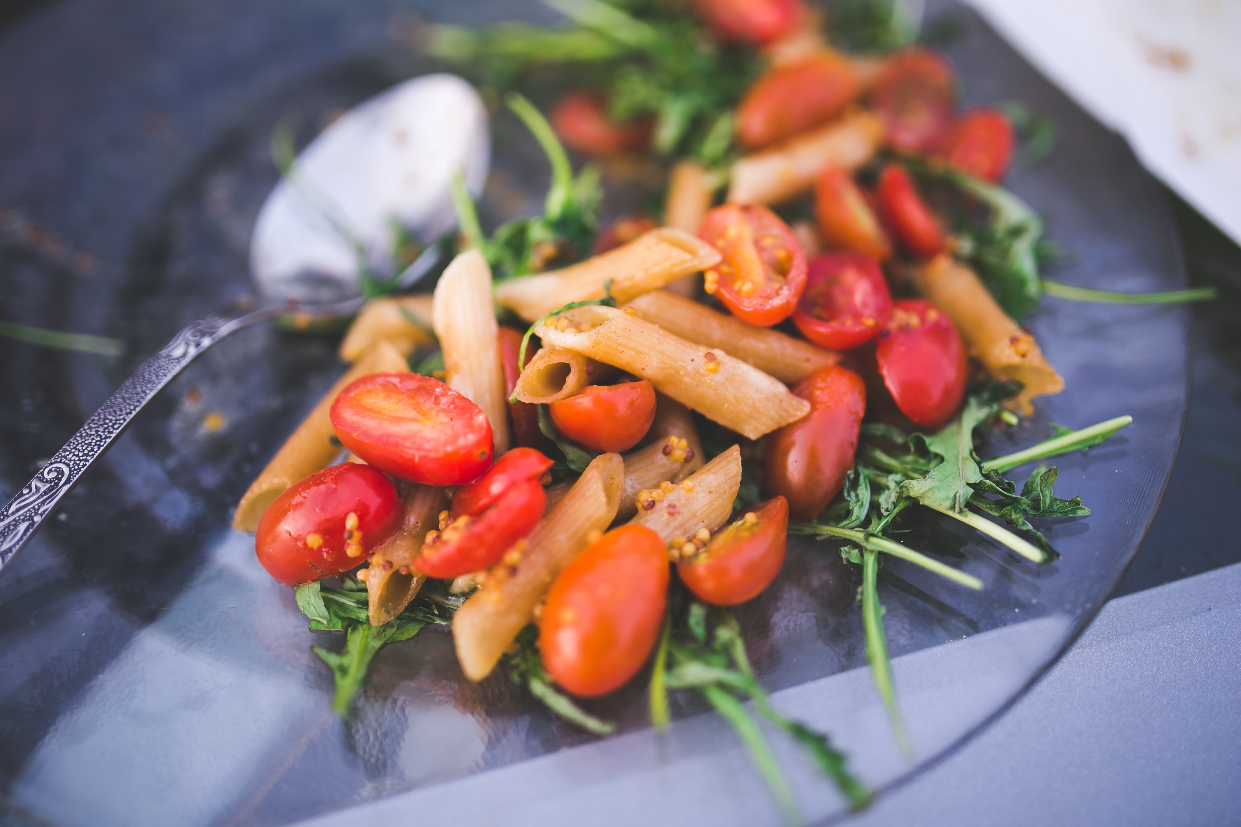 Pasta penne with tomato and rucola photo