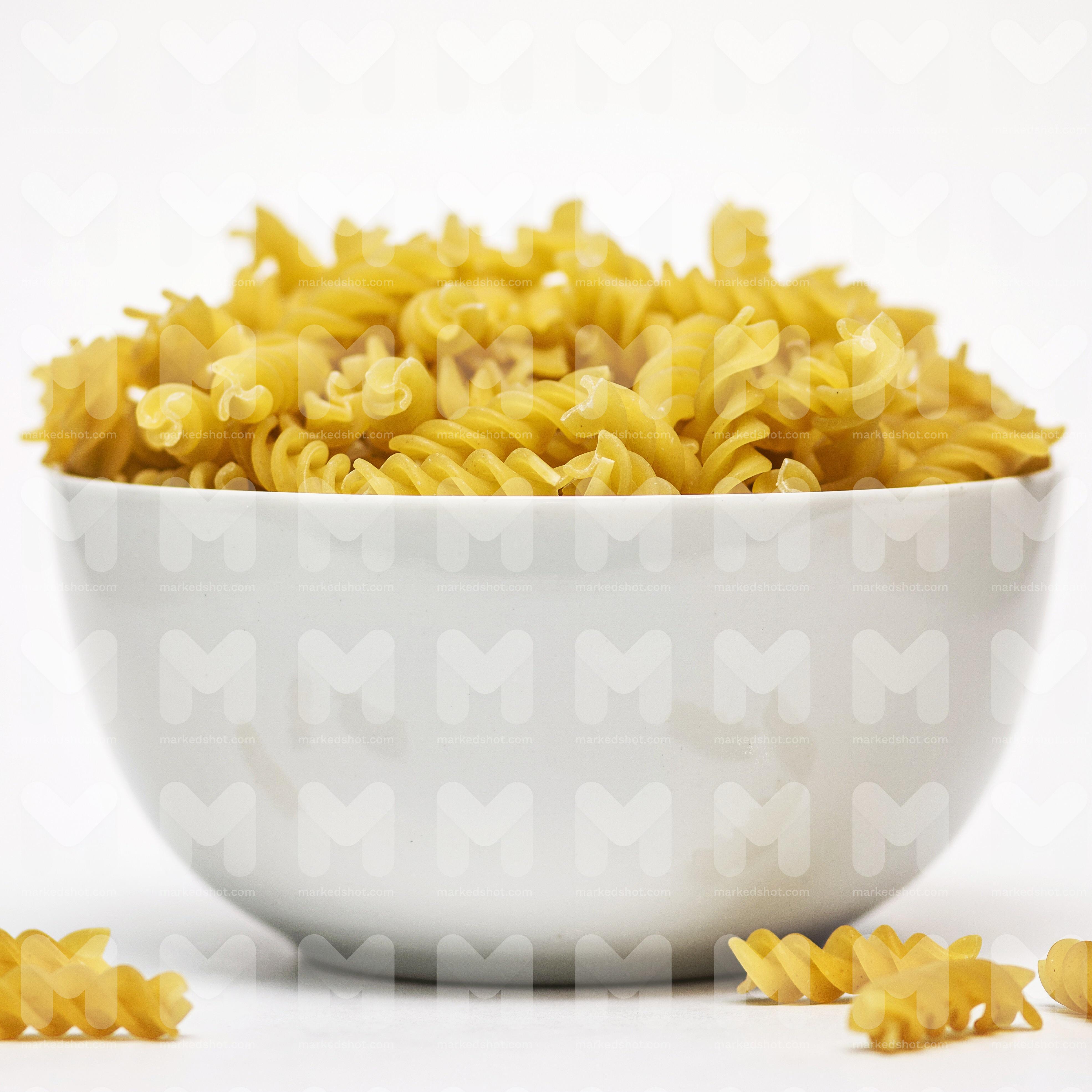 Close up image of some dried pasta twists in a white bowl by Stuart ...