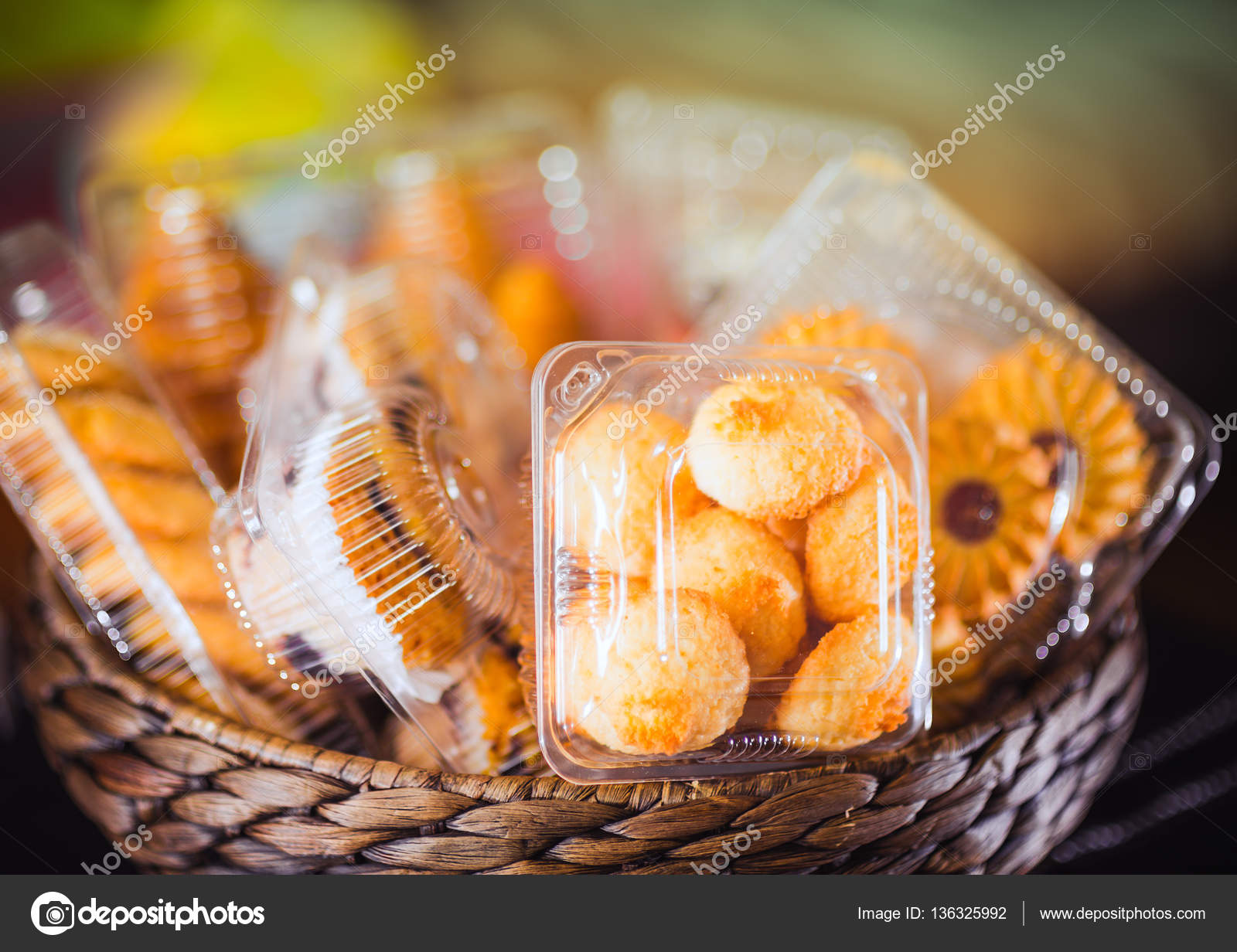 Plastic disposable containers with cookies and pastries in a wicker ...