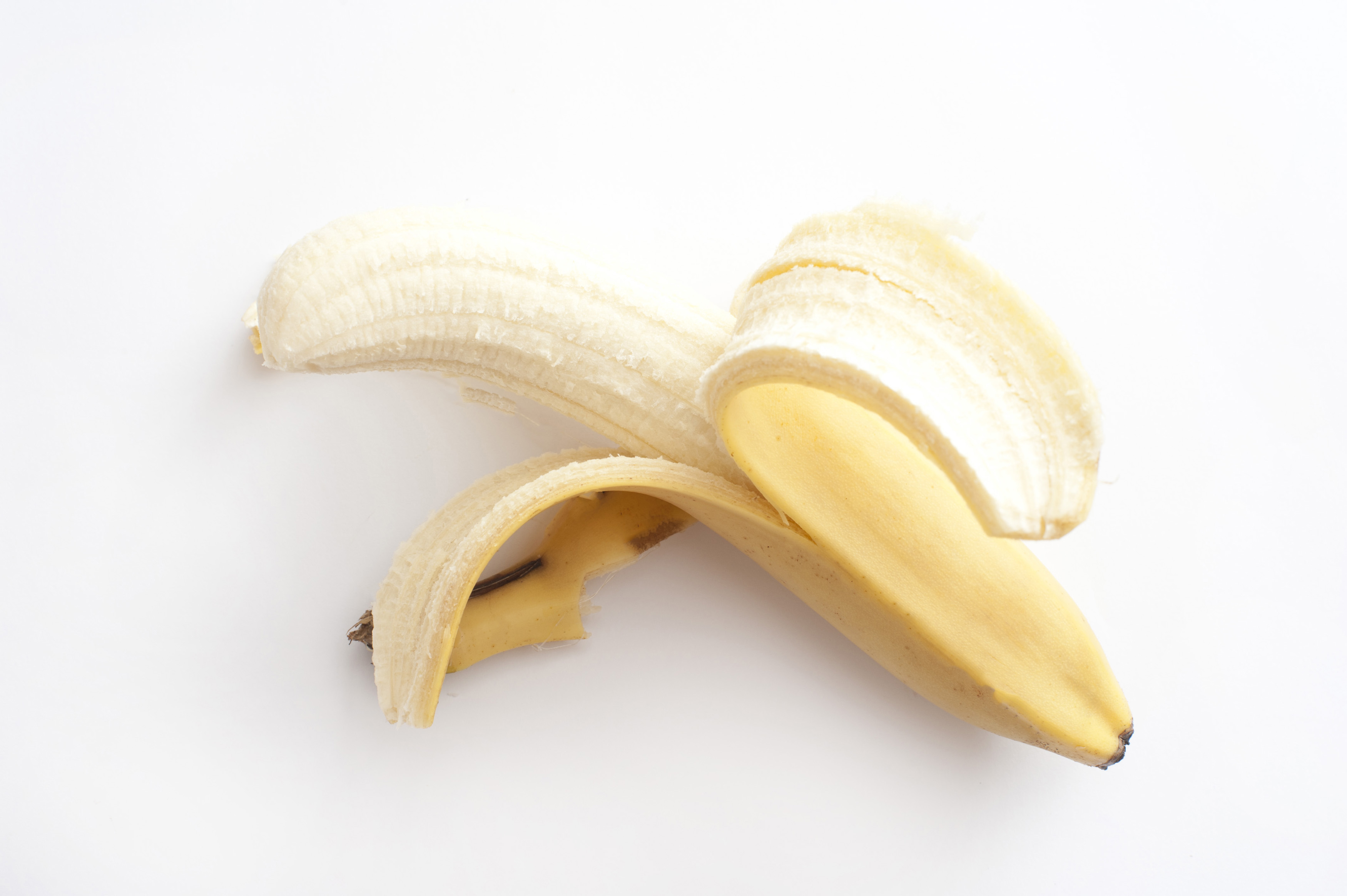 Peeled banana on white background - Free Stock Image