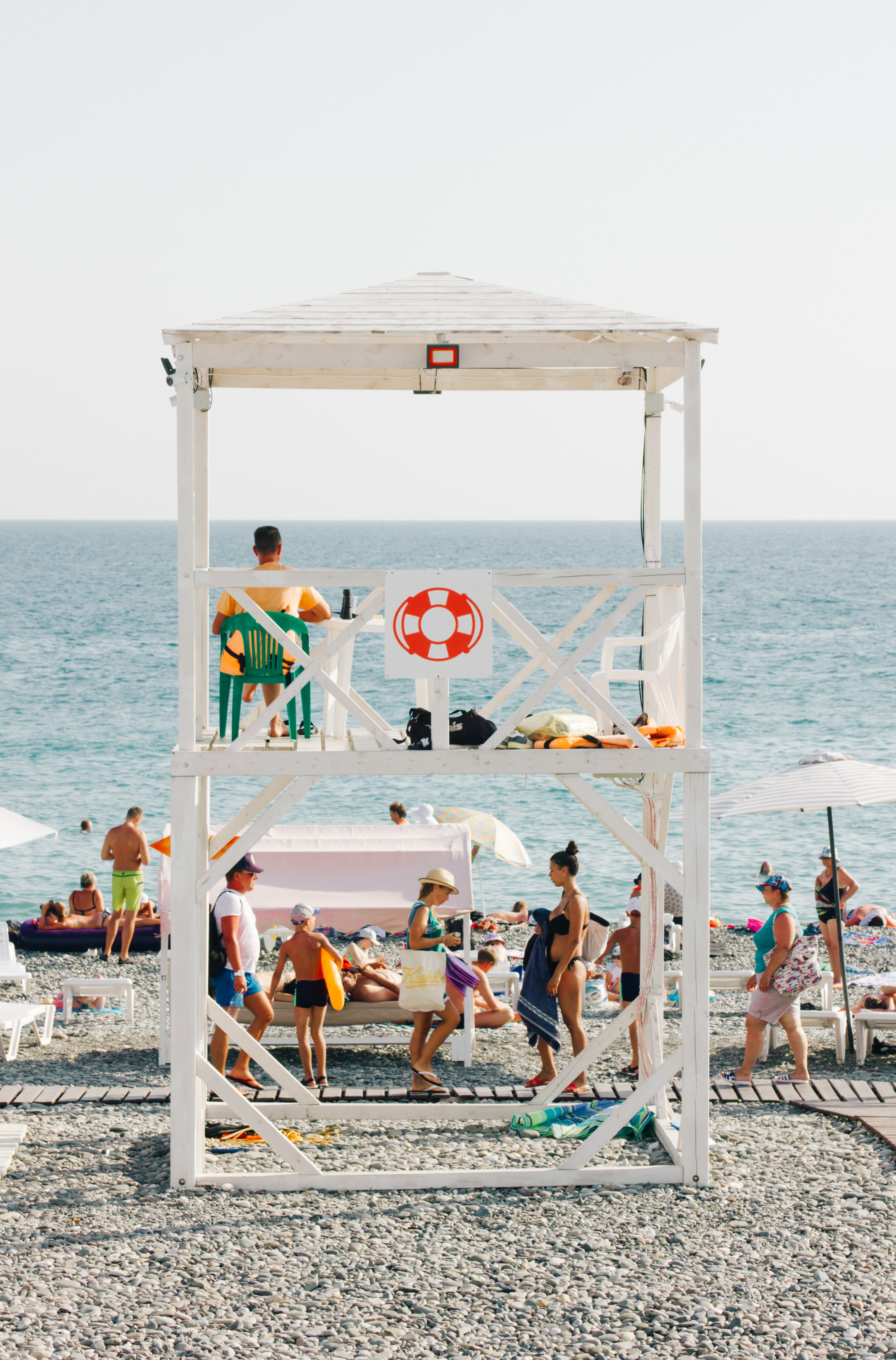 People near beach with lifeguard gazebo photo