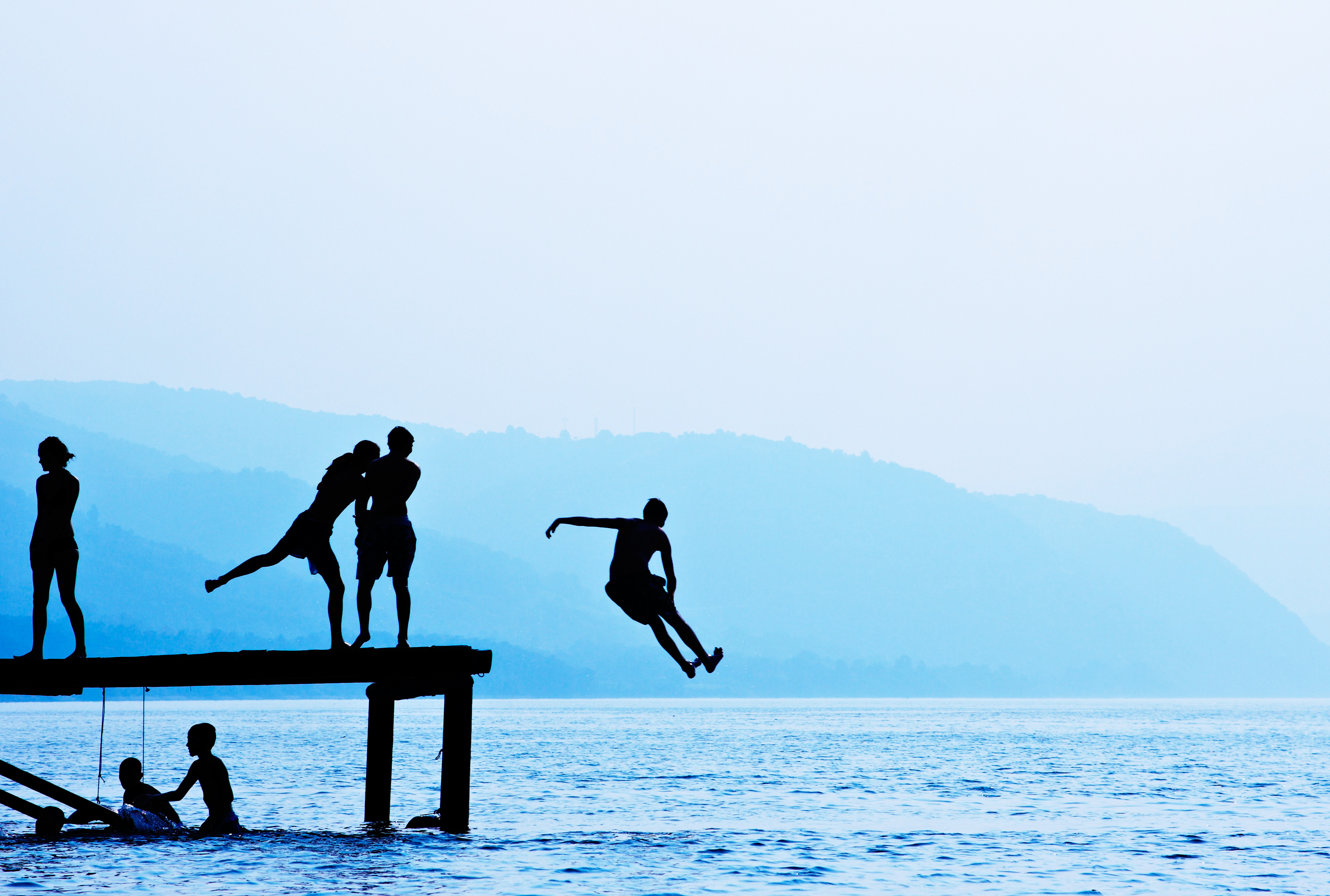 Silhouettes of Kids Jumping Off Dock |