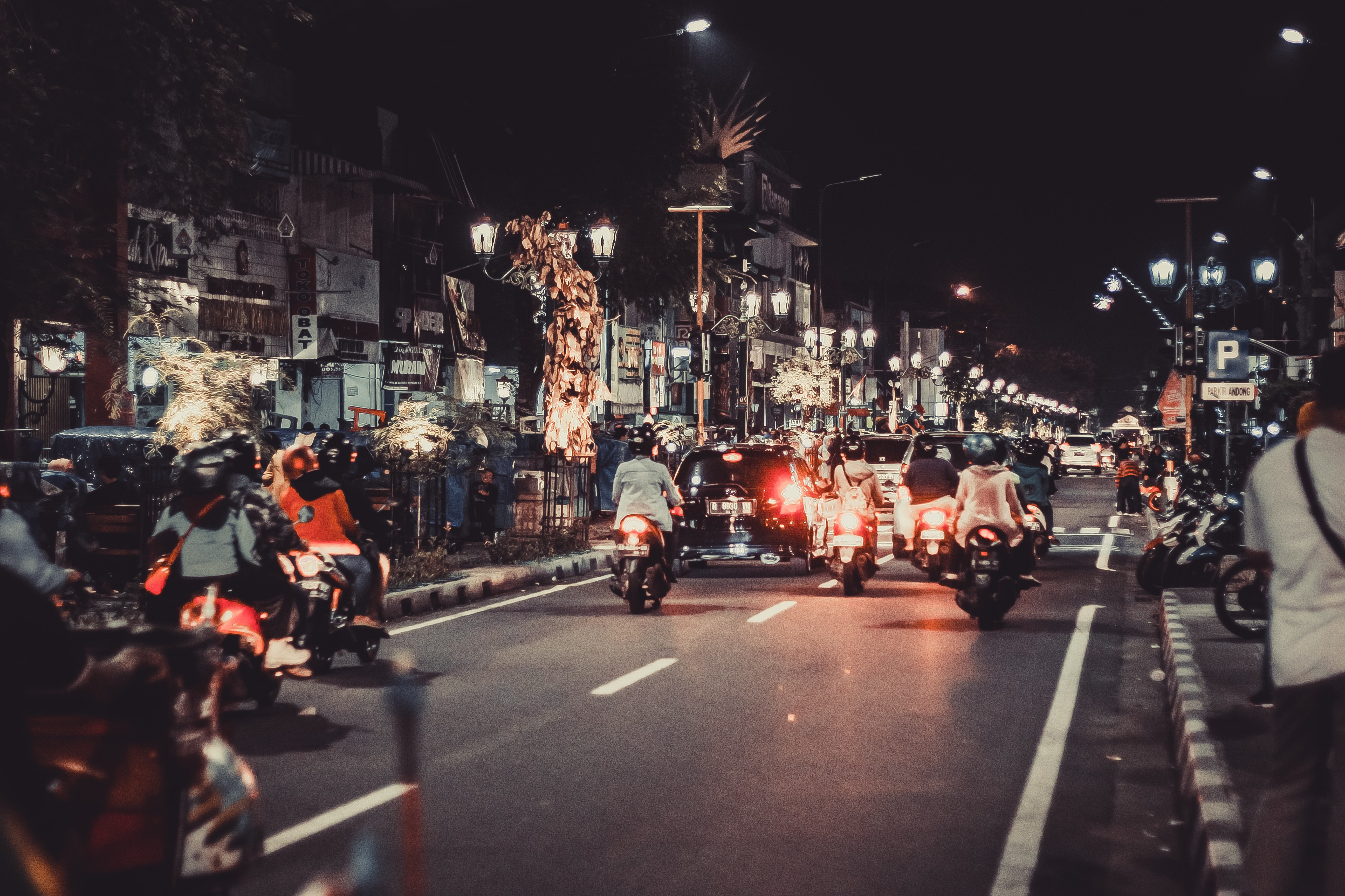 People riding motorcycles on road during night time photo