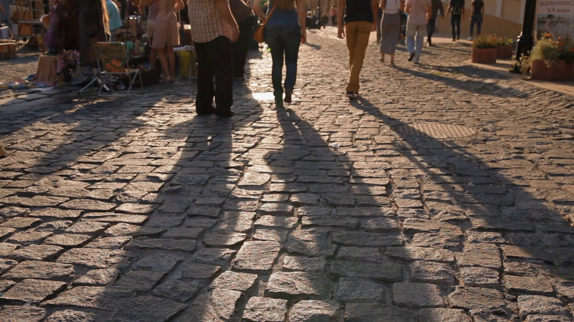 Long shadow of walking in sunset light people on macadam. . Group of ...