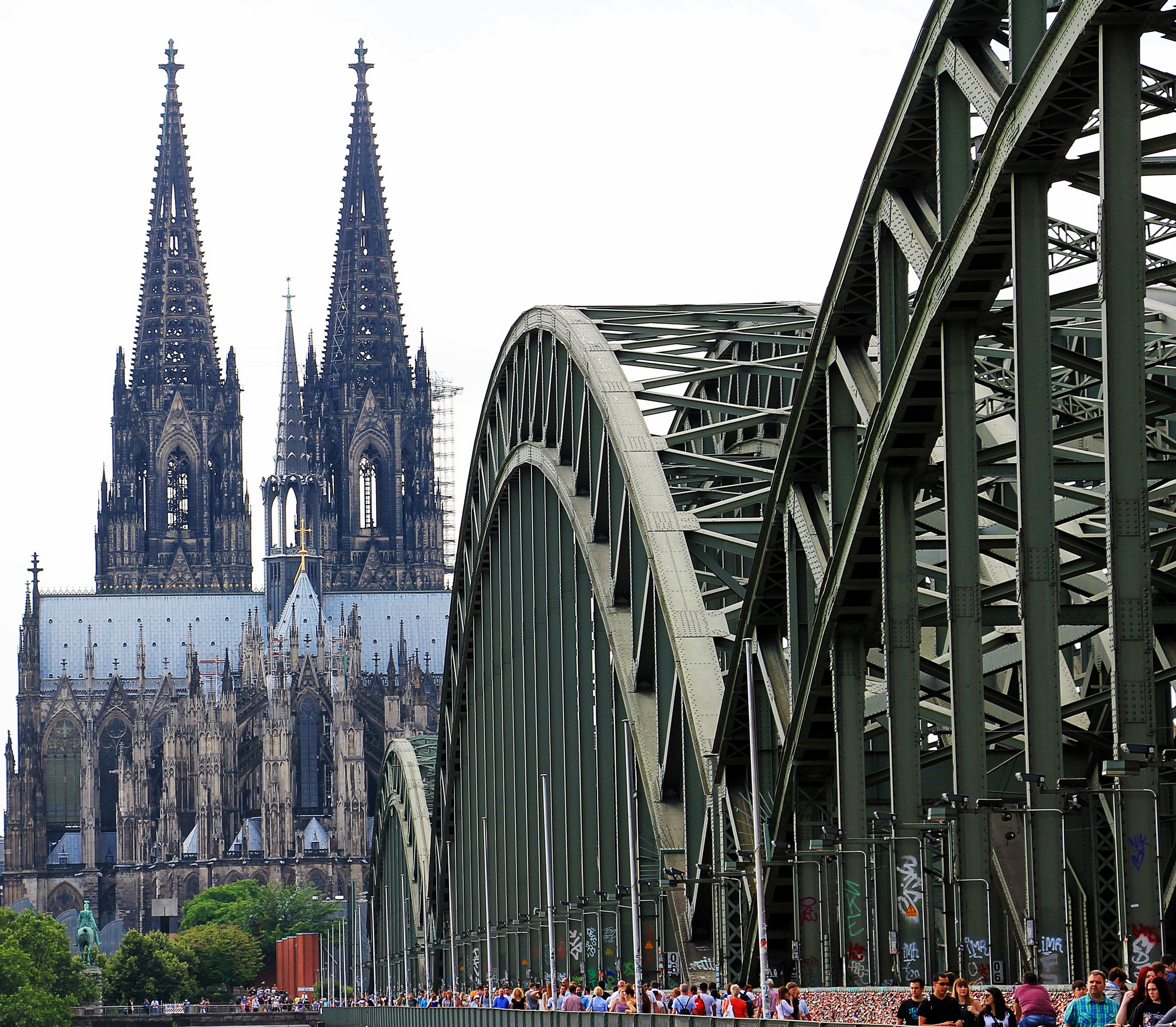 People walling on cologne bridge near cologne cathedral during daytime photo