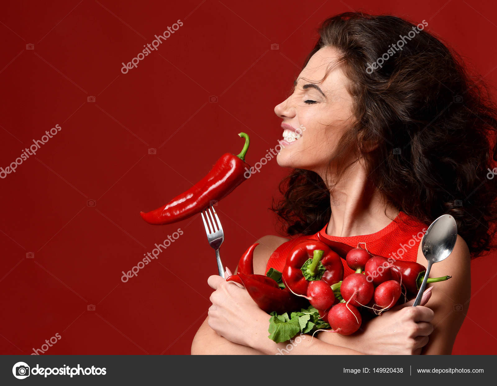 young woman posing with fresh red vegetables radish chilli peppe ...