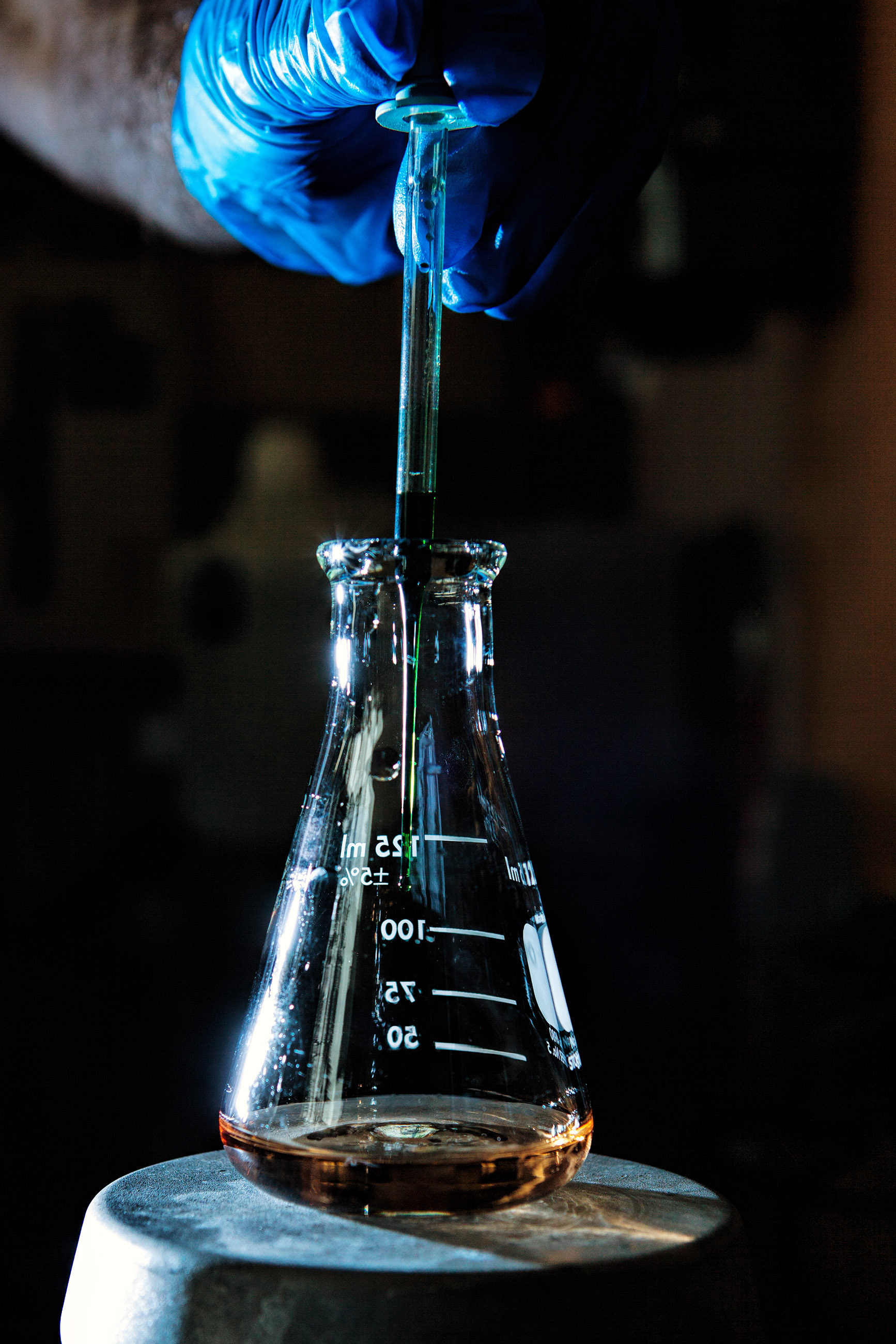 Person adding chemicals to a flask photo