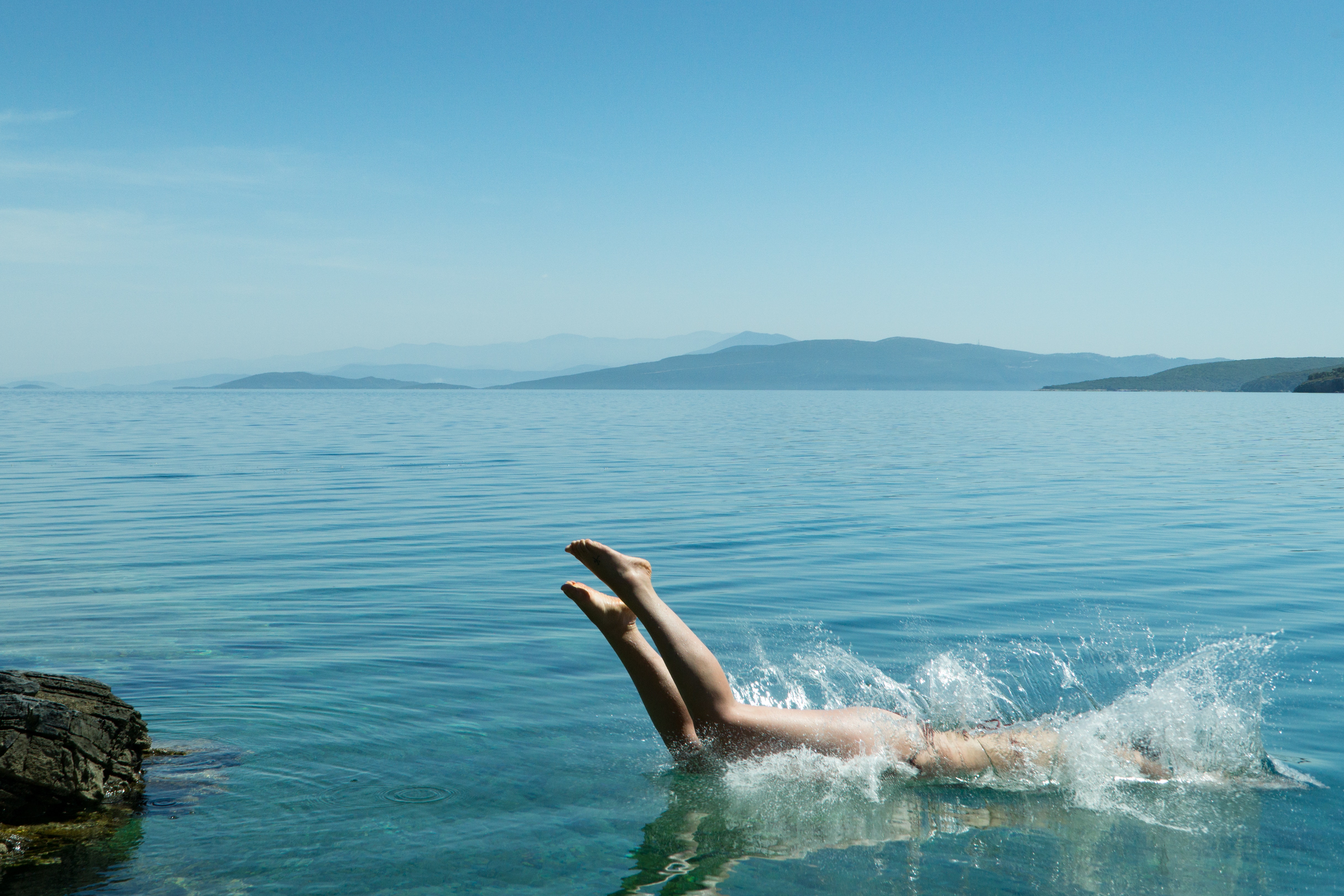 Person diving on body of water during daytime photo