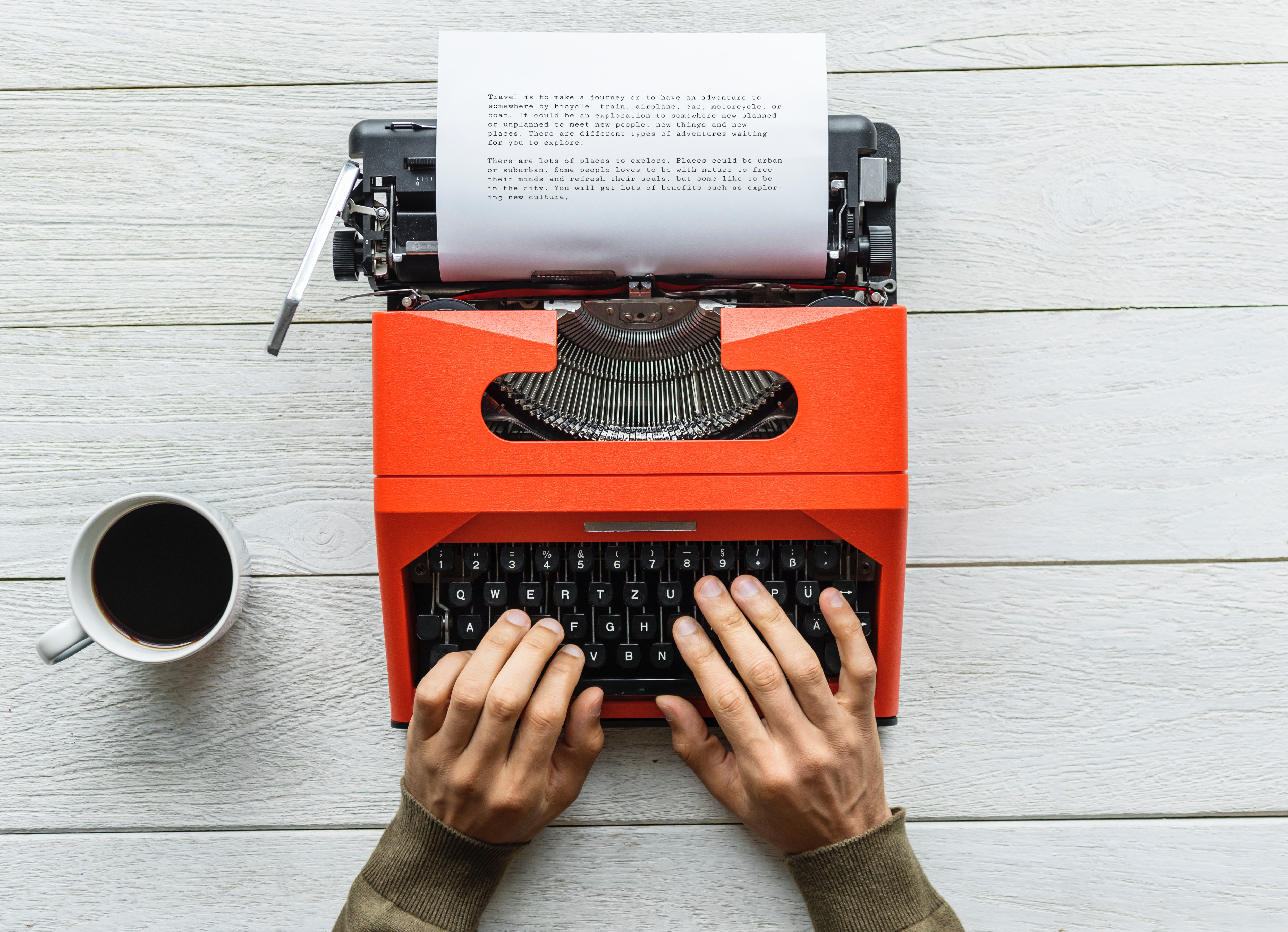 Person holding black and orange typewriter photo