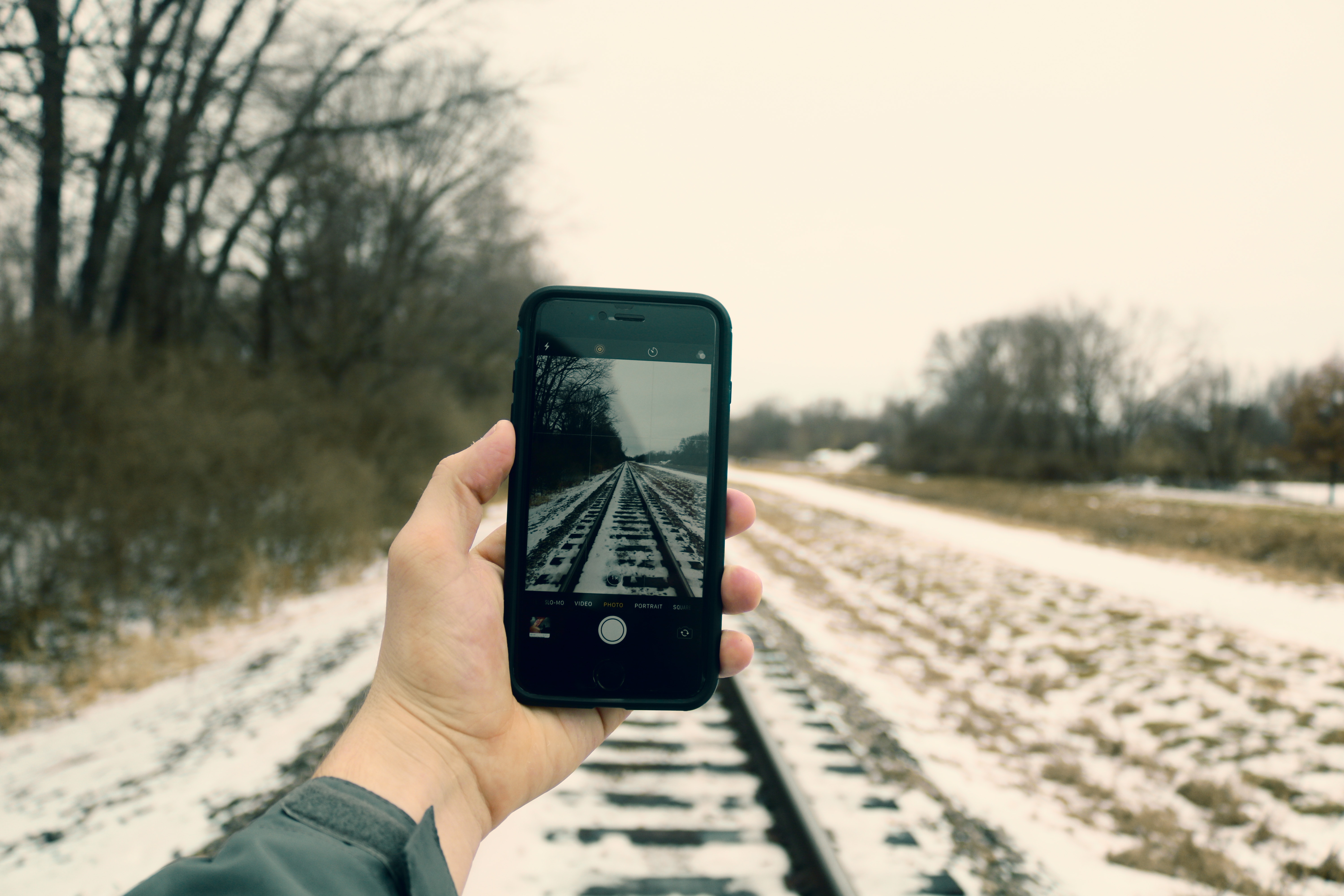 Person Holding Iphone Taking Photo of Train Rails, Blur, Phone, Winter, Trees, HQ Photo