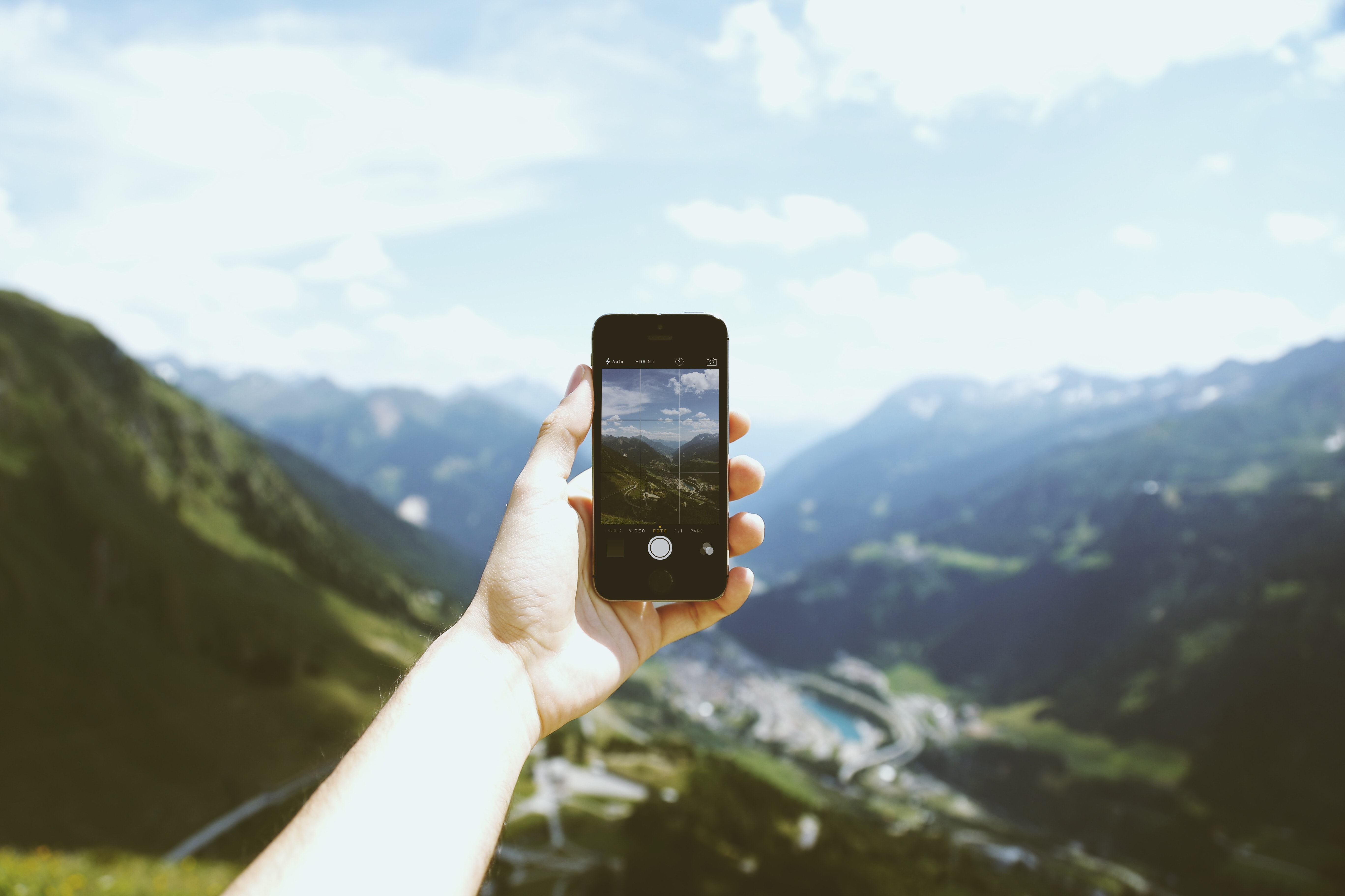 Person holding space gray iphone 5s taking picture of mountains photo