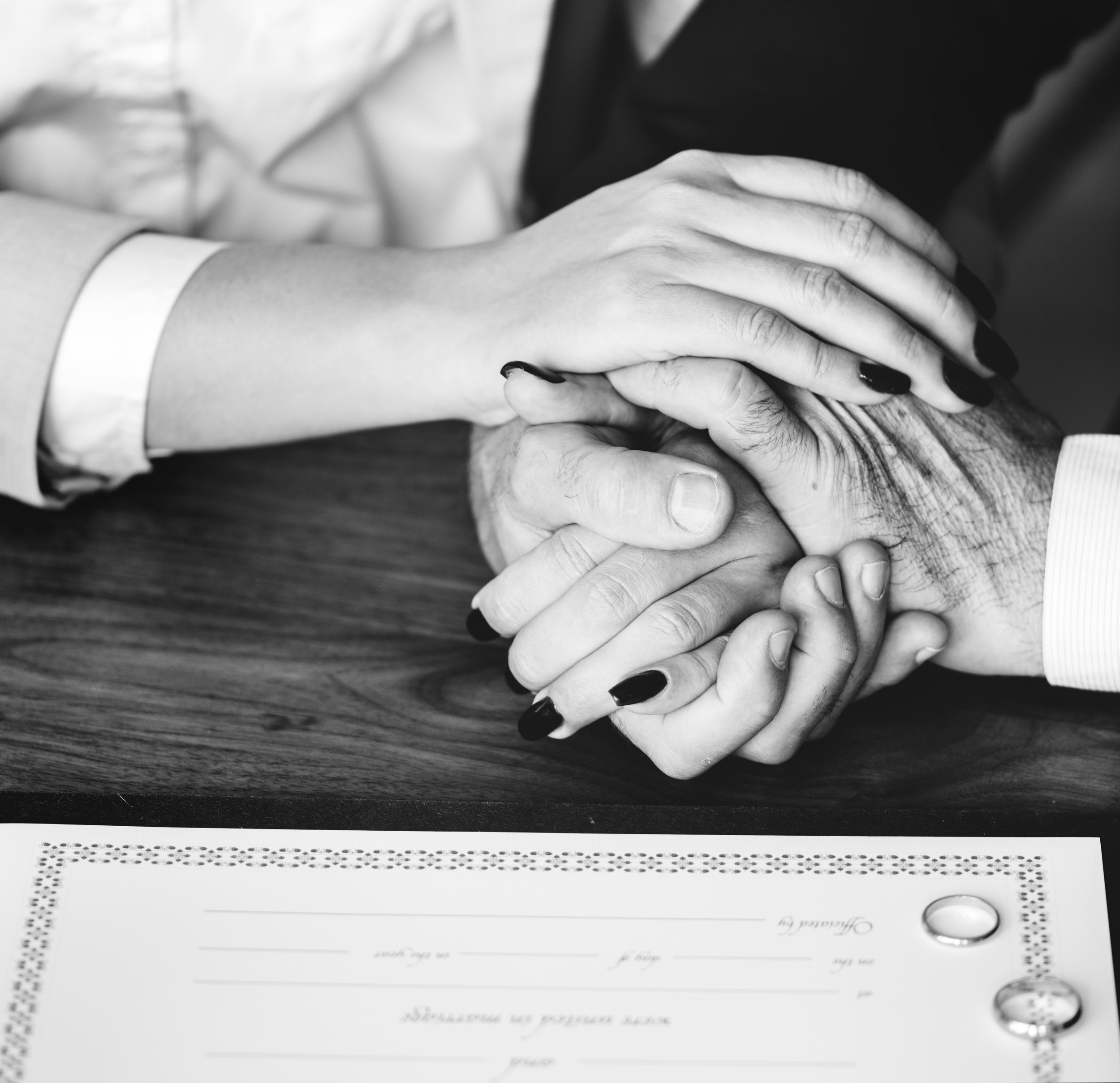 Person holding their hands on brown wooden table photo