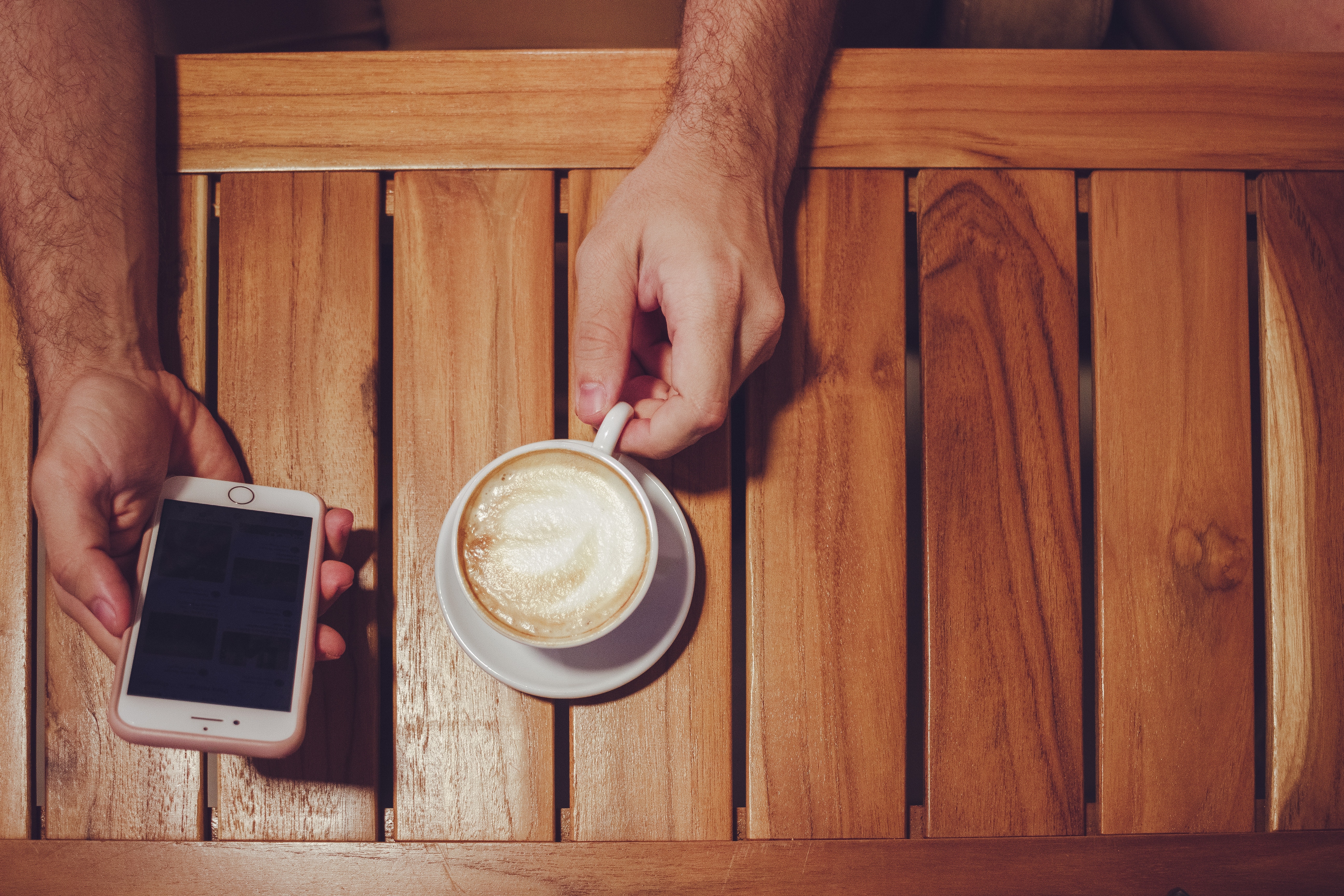 Person Holding Turned Off Gold Iphone 6 With Case and White Ceramic Cup Filled With Latte, Iphone, Wooden, Wood, Table, HQ Photo