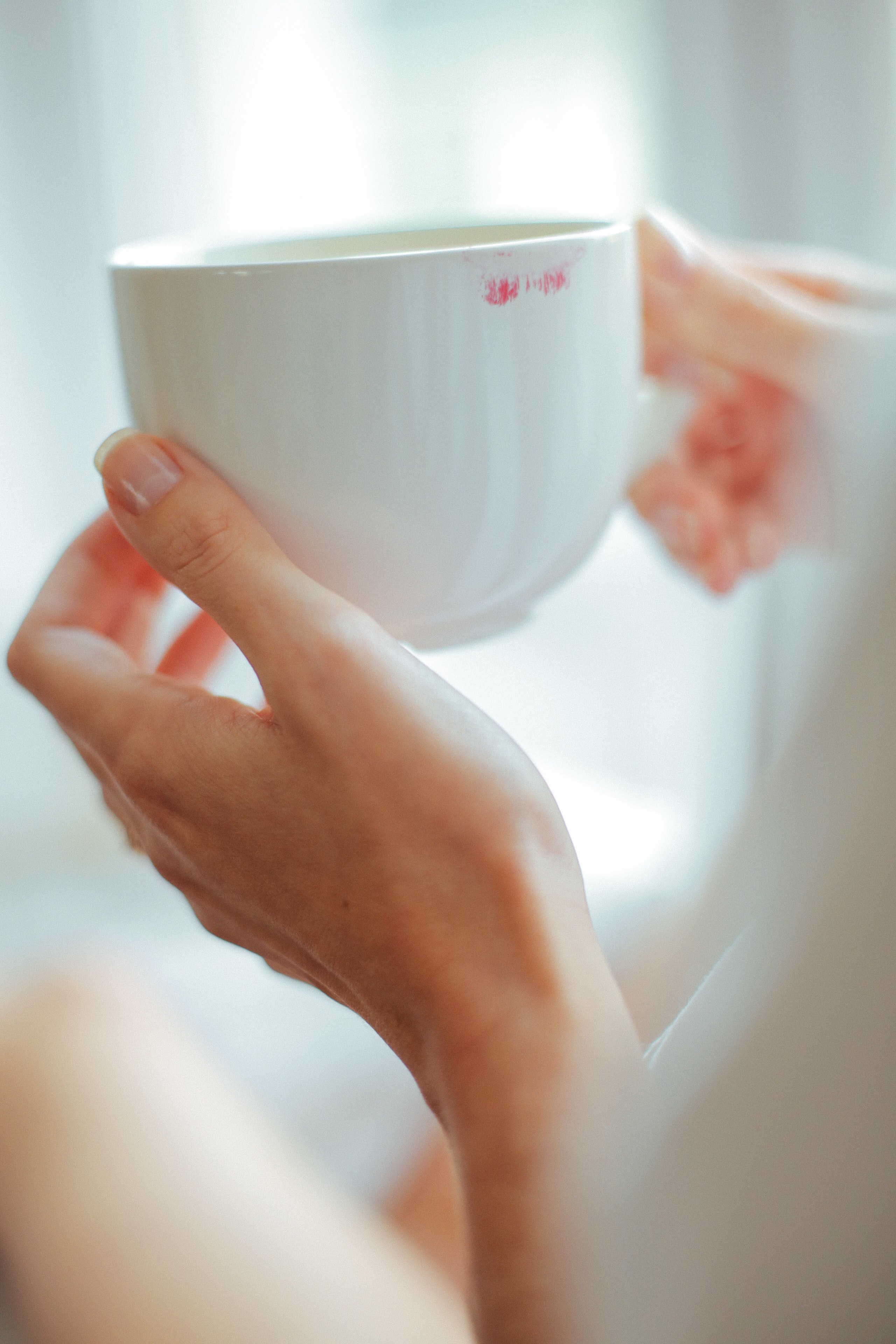 Person holding white ceramic teacup photo