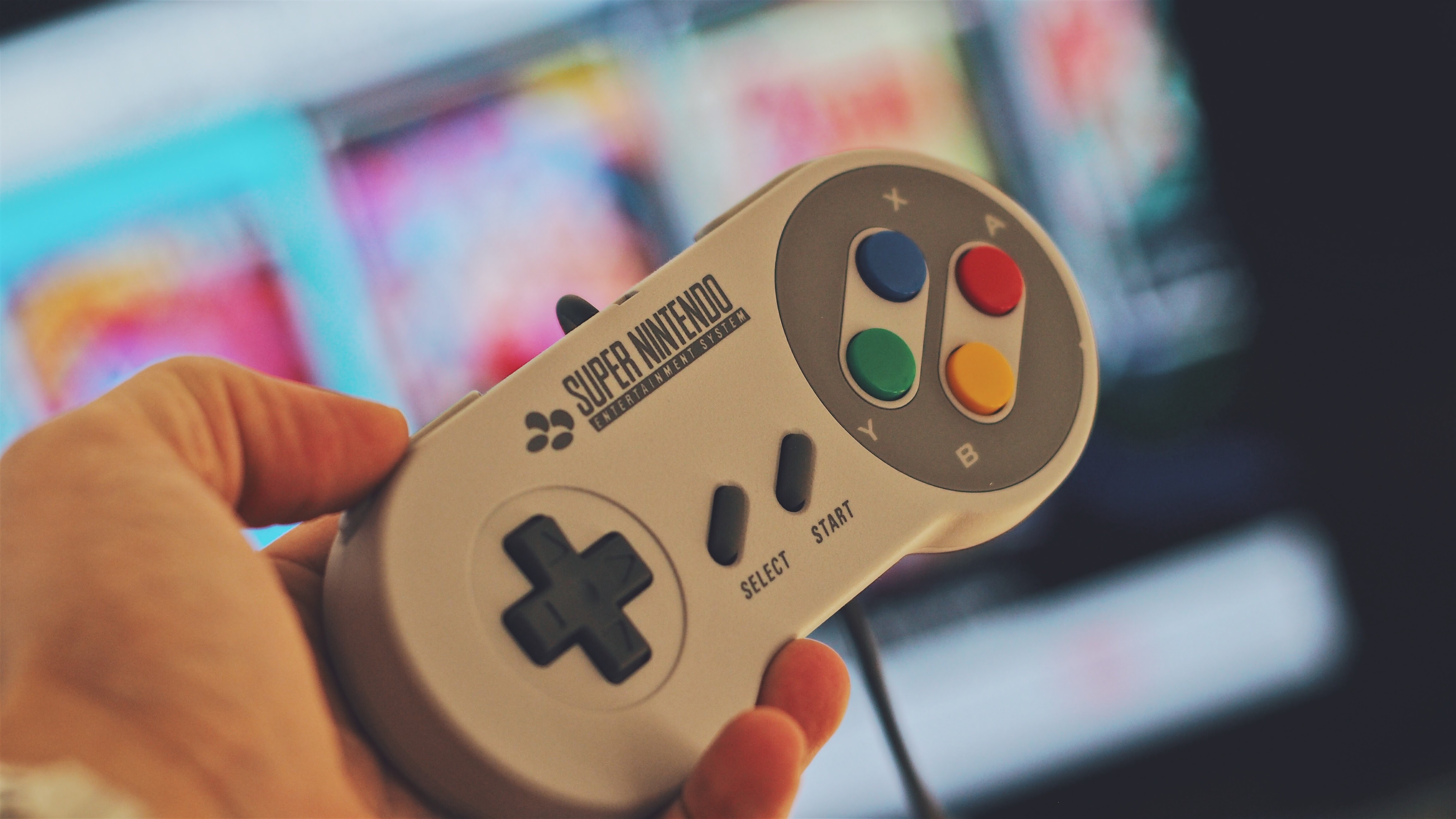 Person holding white snes controller photo