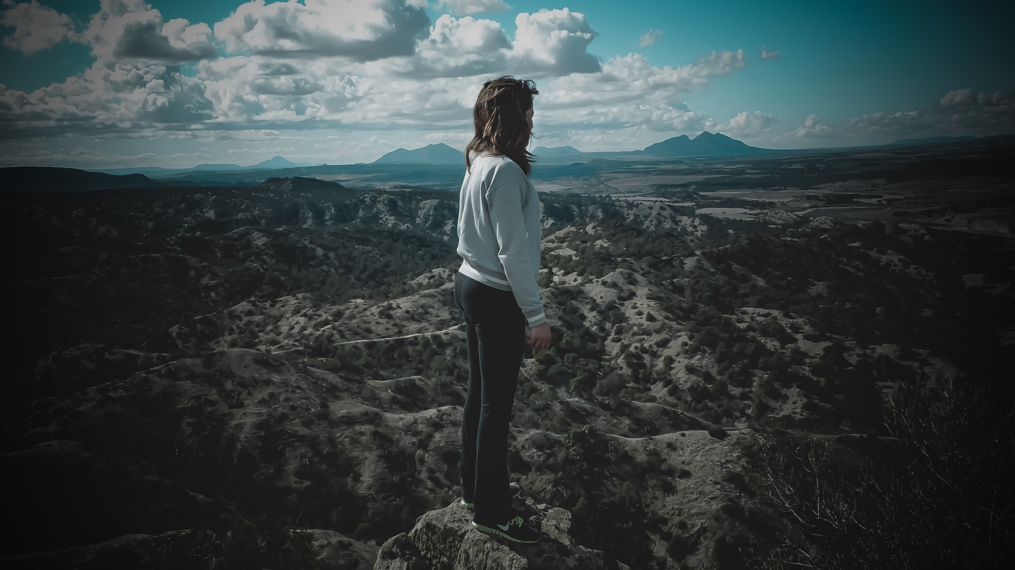 Person in gray long-sleeved shirt standing on top of mountain photo