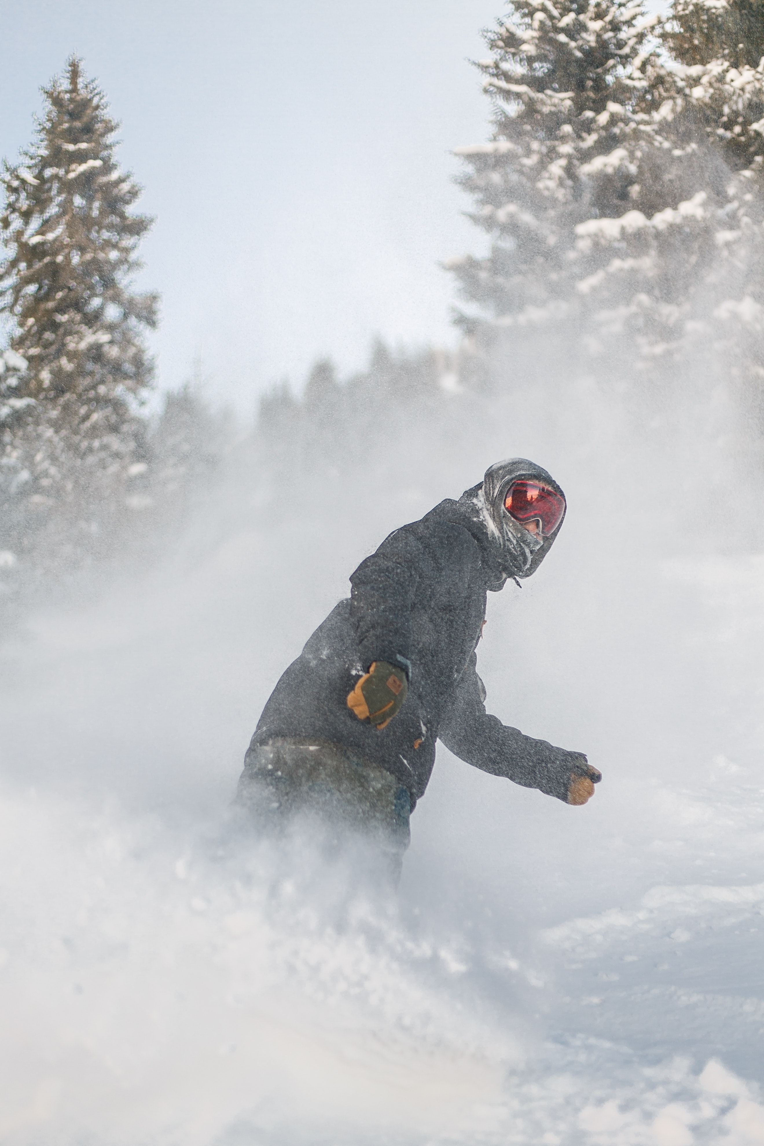 Person in grey jacket and red snow goggles riding on snowboard photo