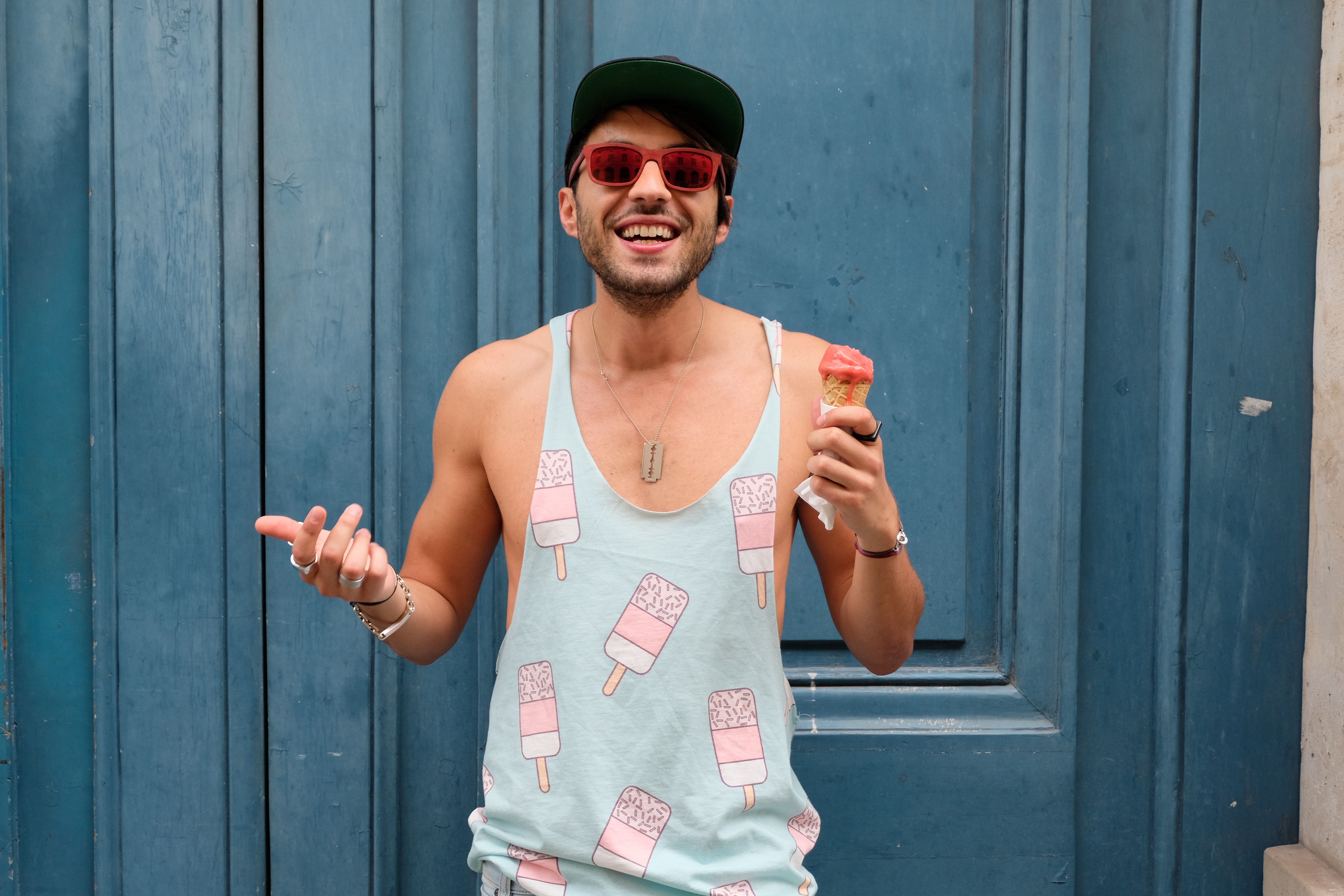 Person in teal ice cream print tank top holds ice cream photo