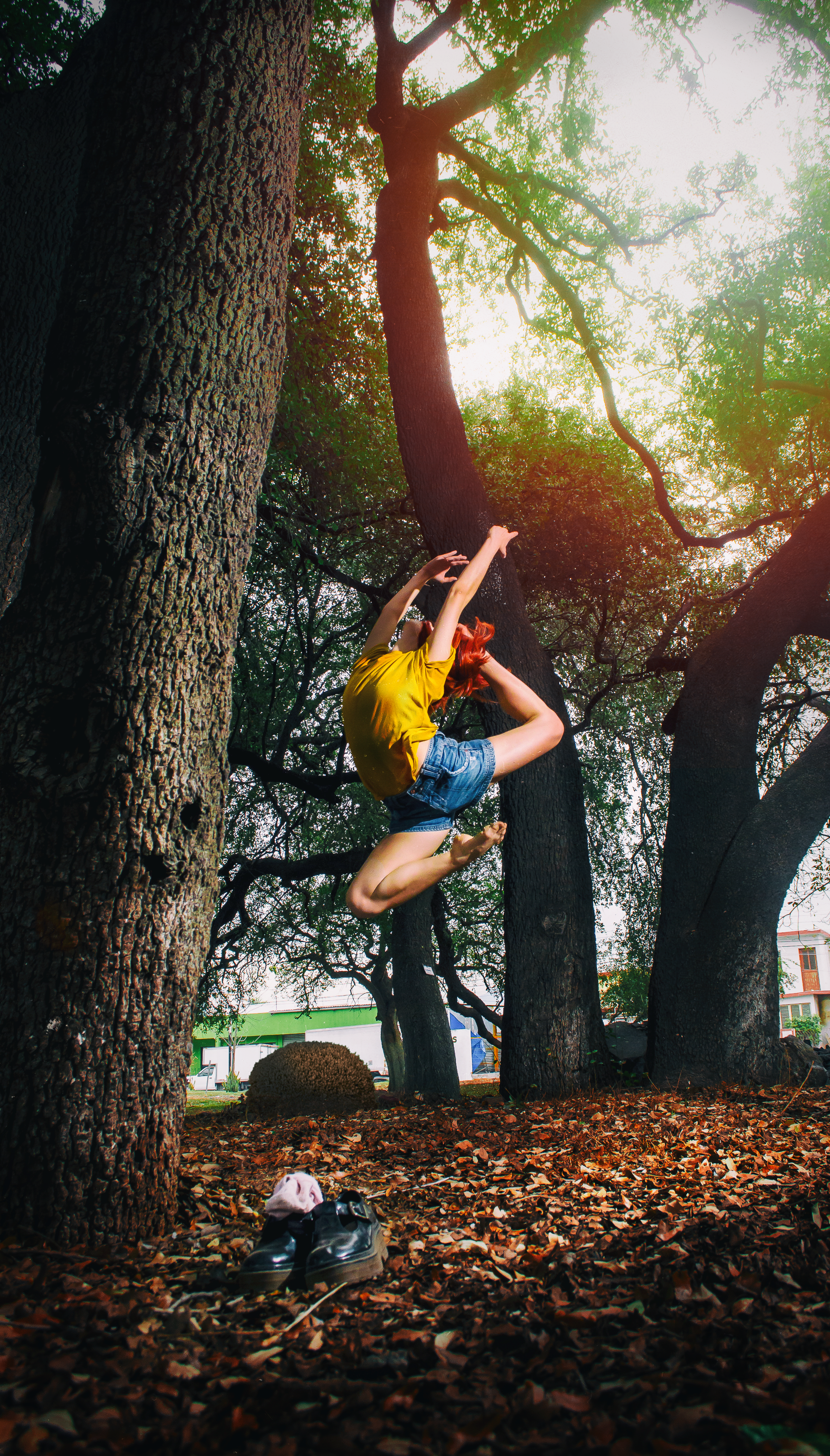 Person in yellow shirt and blue denim shorts doing ballet stance on woods photo
