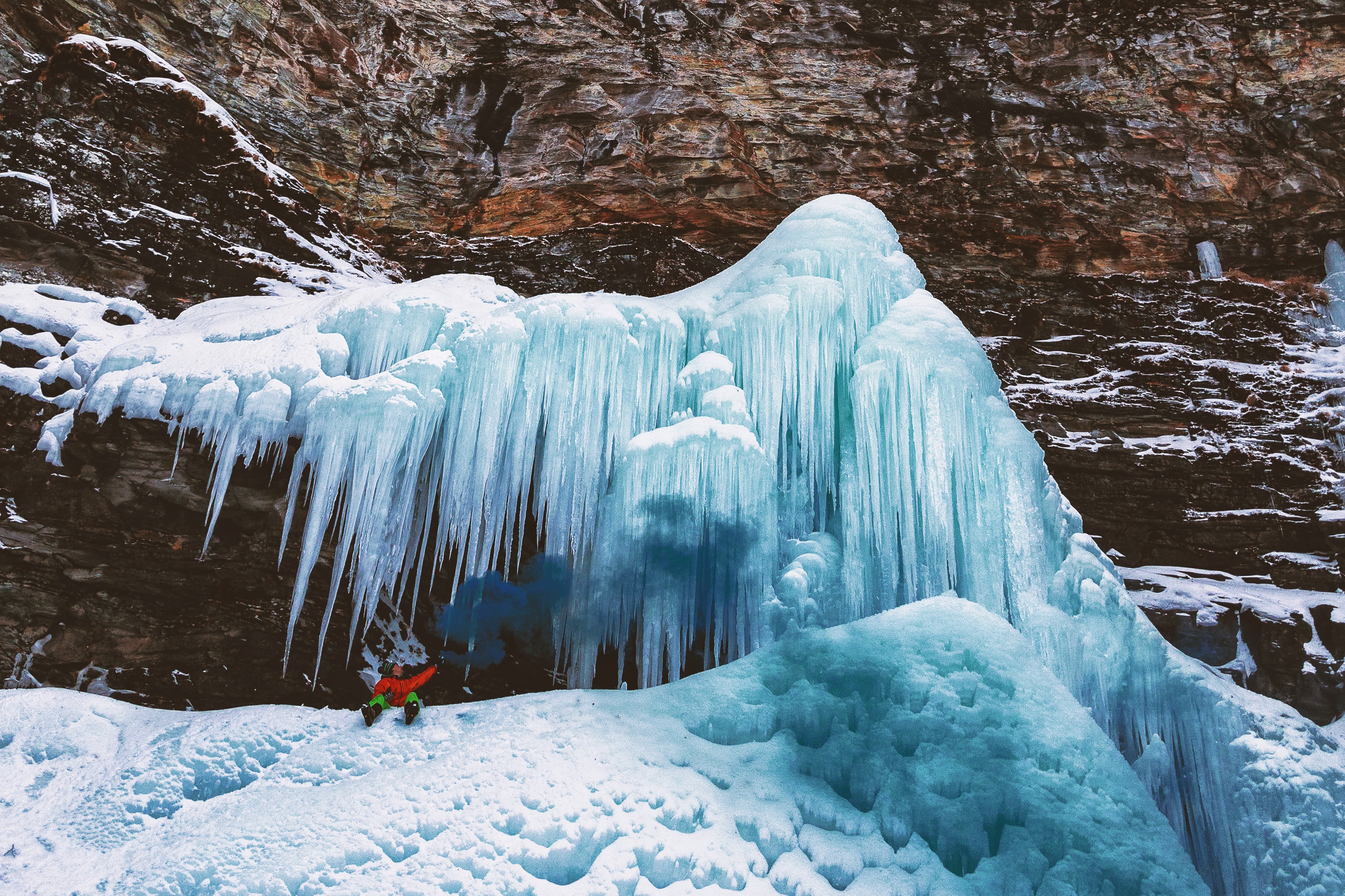 Person sits on mountain with icicles photo
