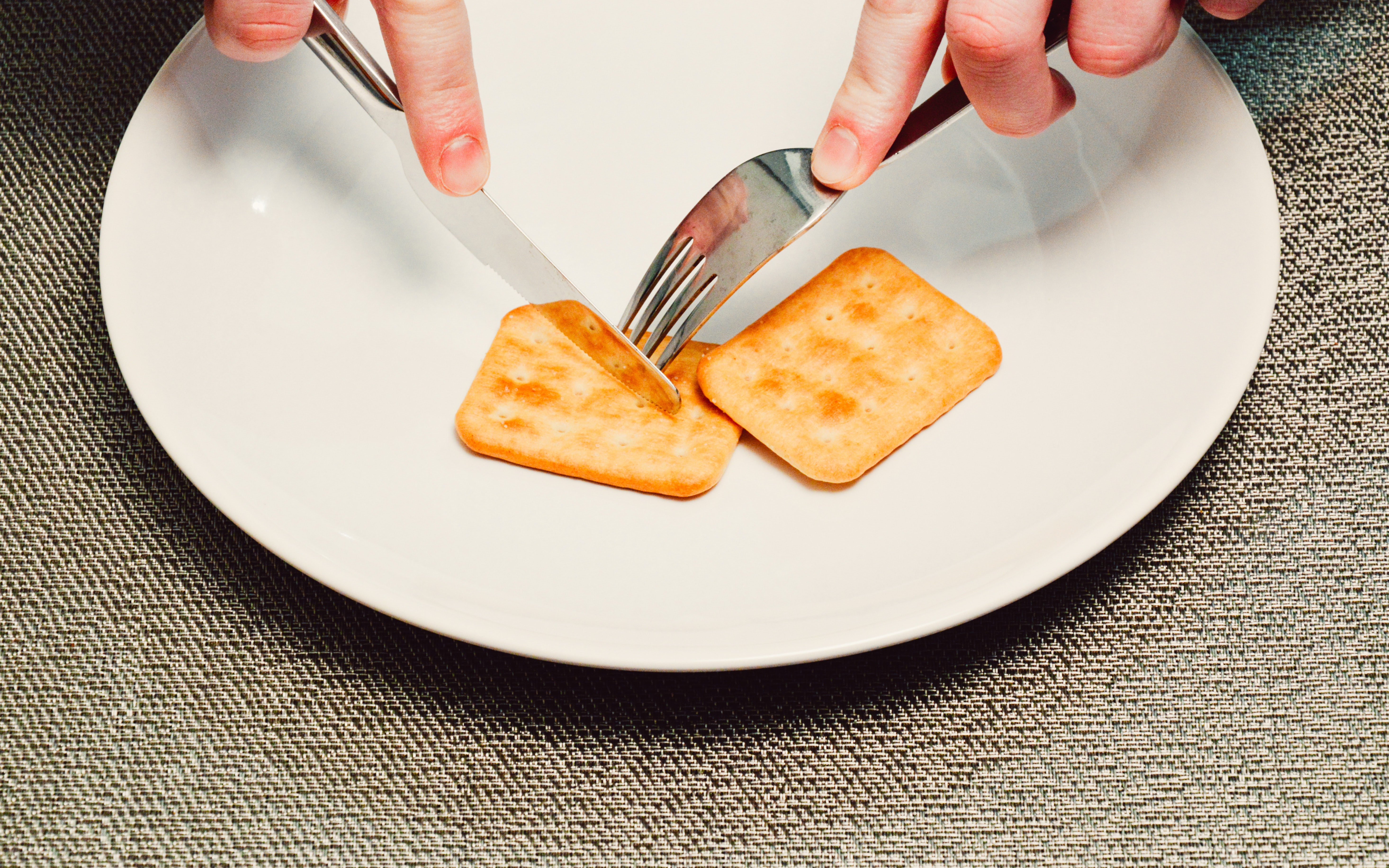 Person slicing biscuit using stainless steel butter knife photo