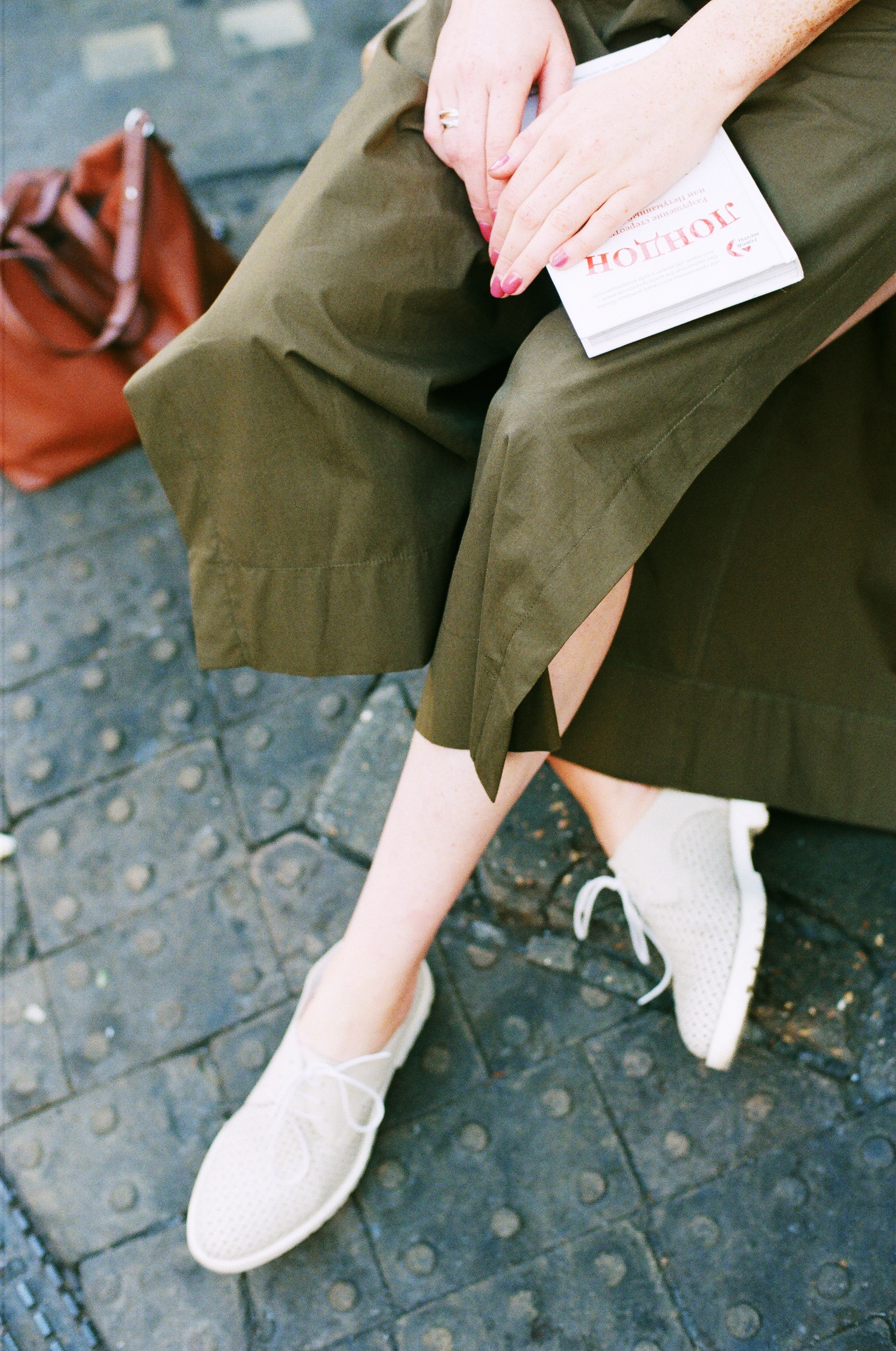 Person wearing green skirt and pair of white low top sneakers photo