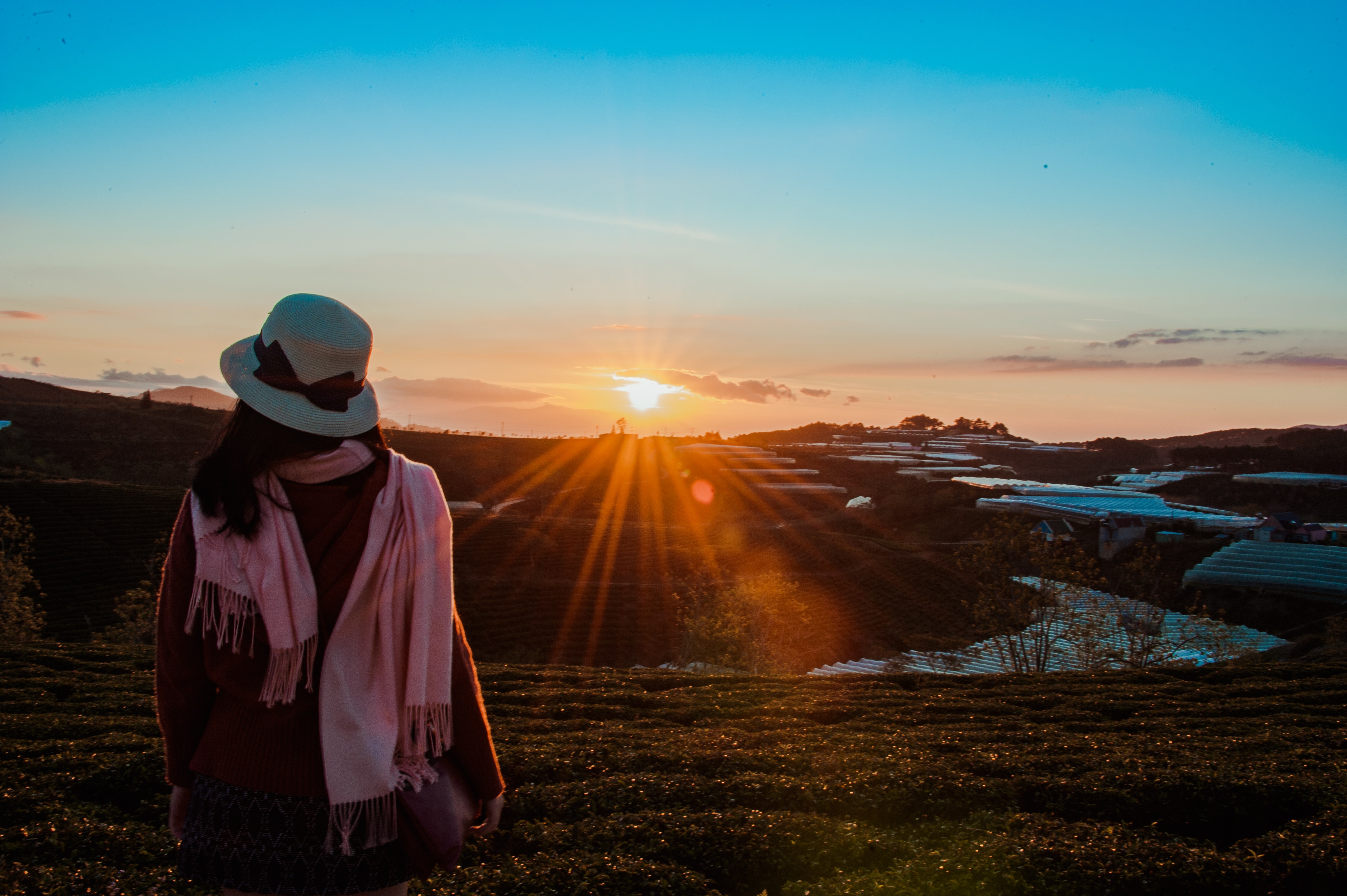 Person wearing white fedora hat and pink scarf during golden hour photo