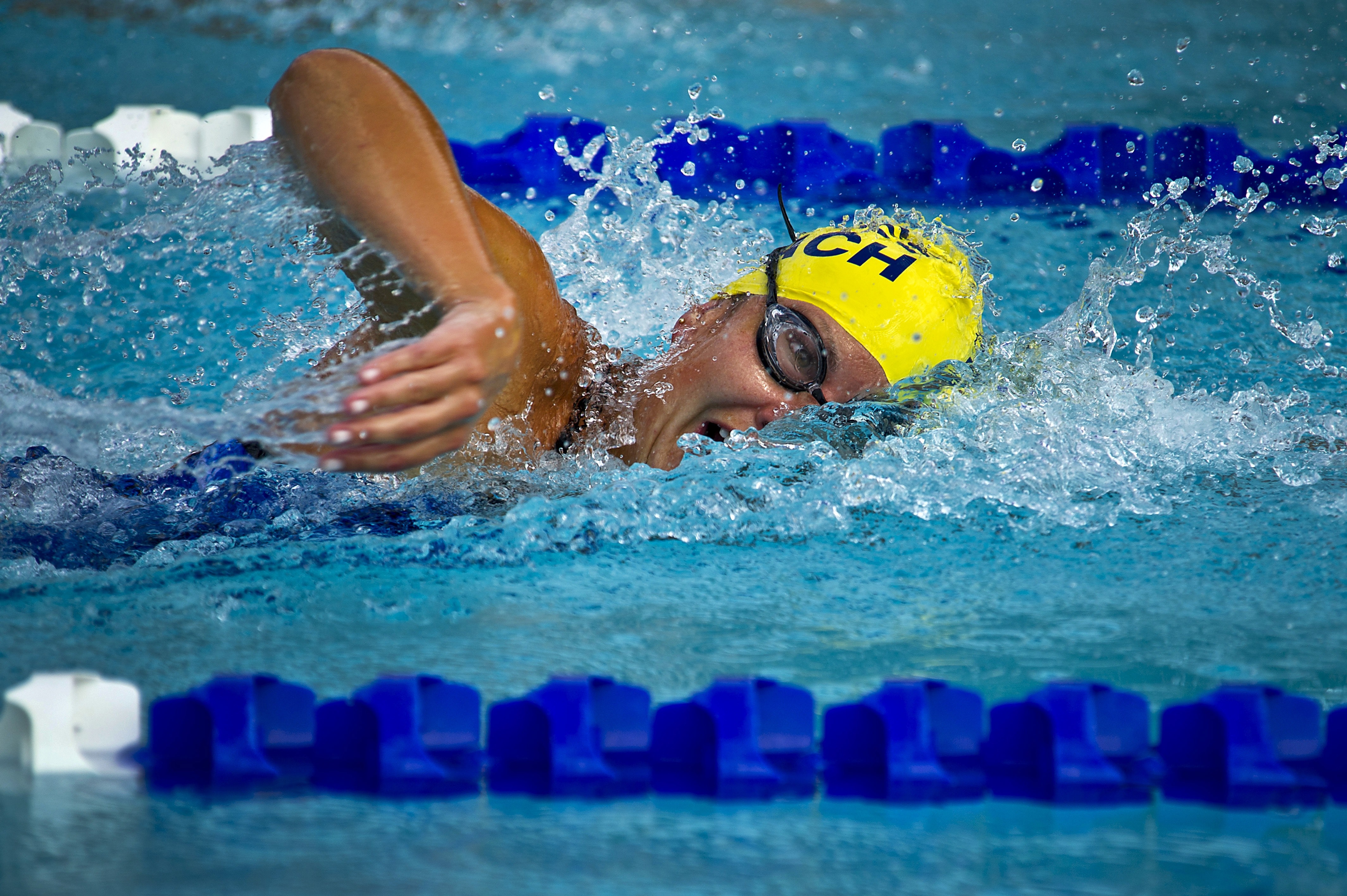 Person wearing yellow swimming cap on swimming pool photo