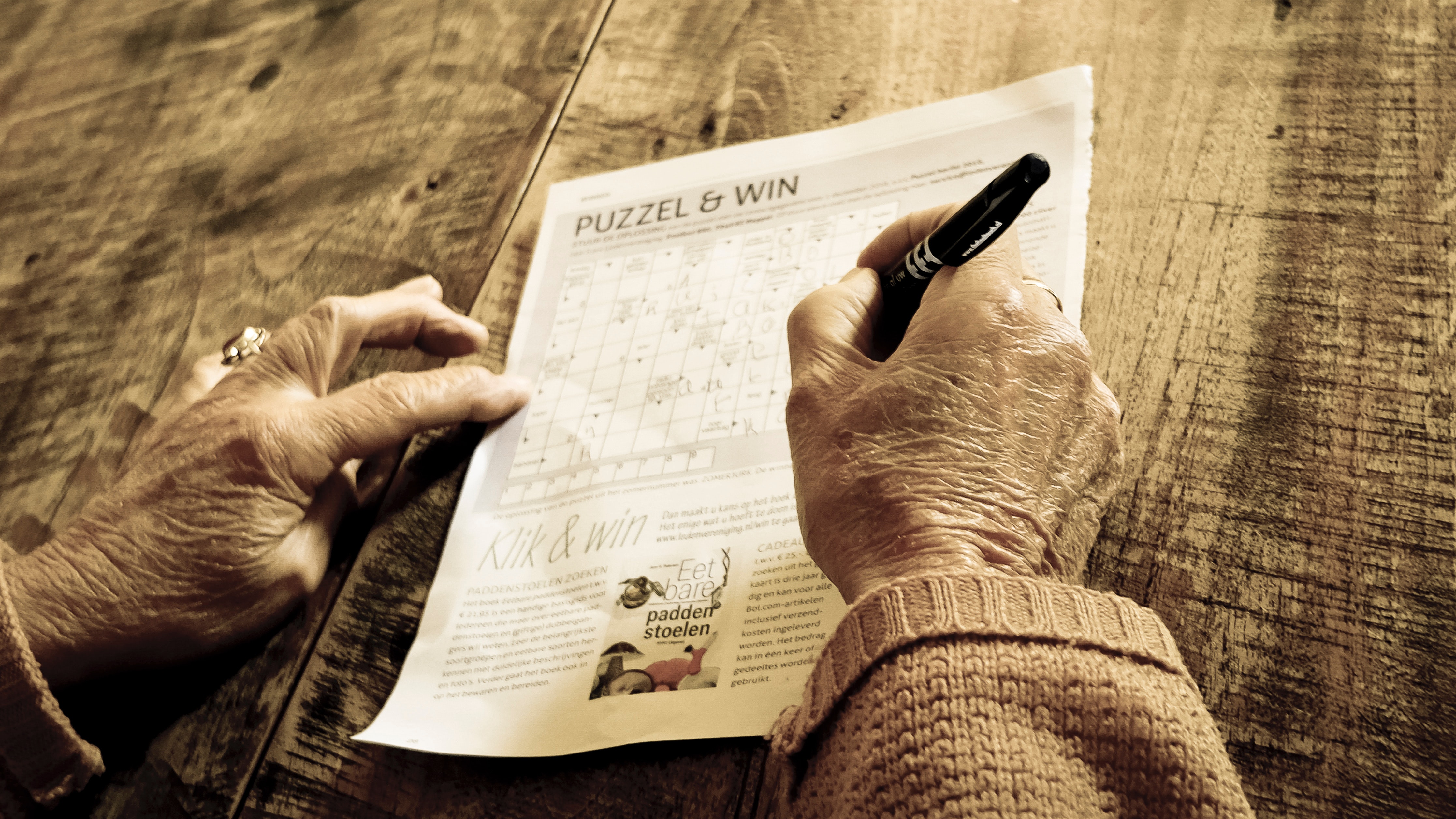 Person writing on puzzle & win paper photo