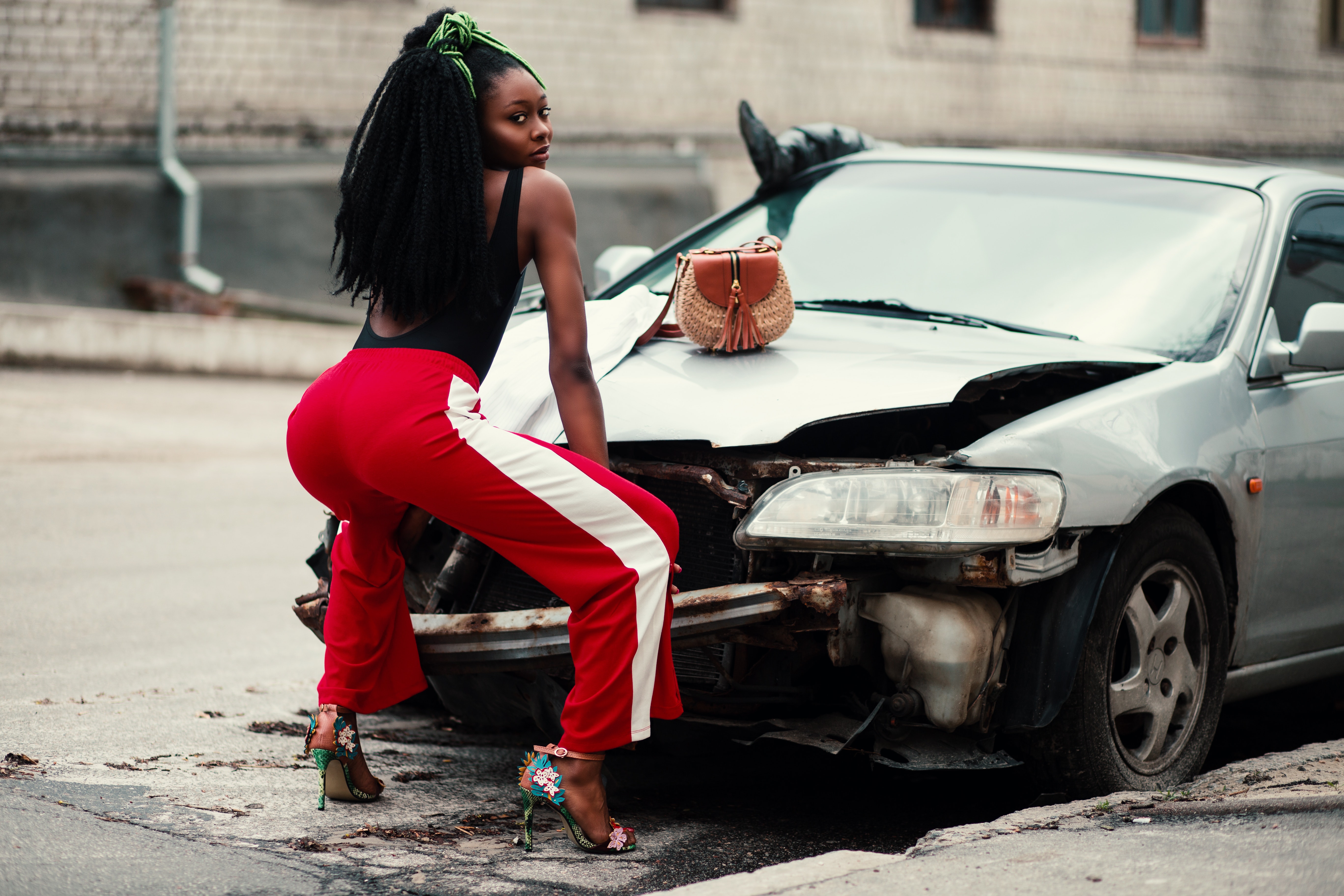 Photograph of woman about to twerk in front of vehicle