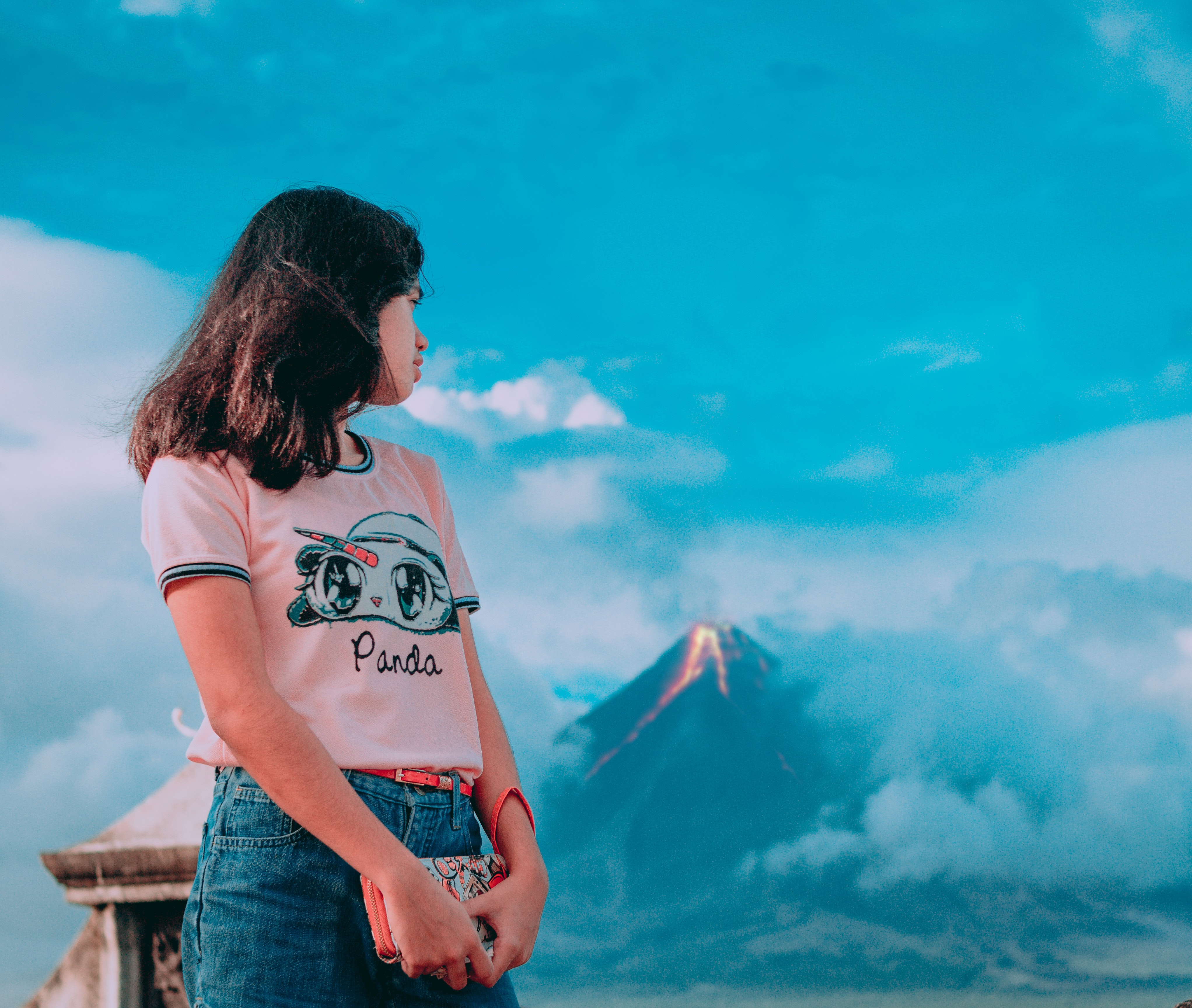 Photography of a girl in front of erupting volcano