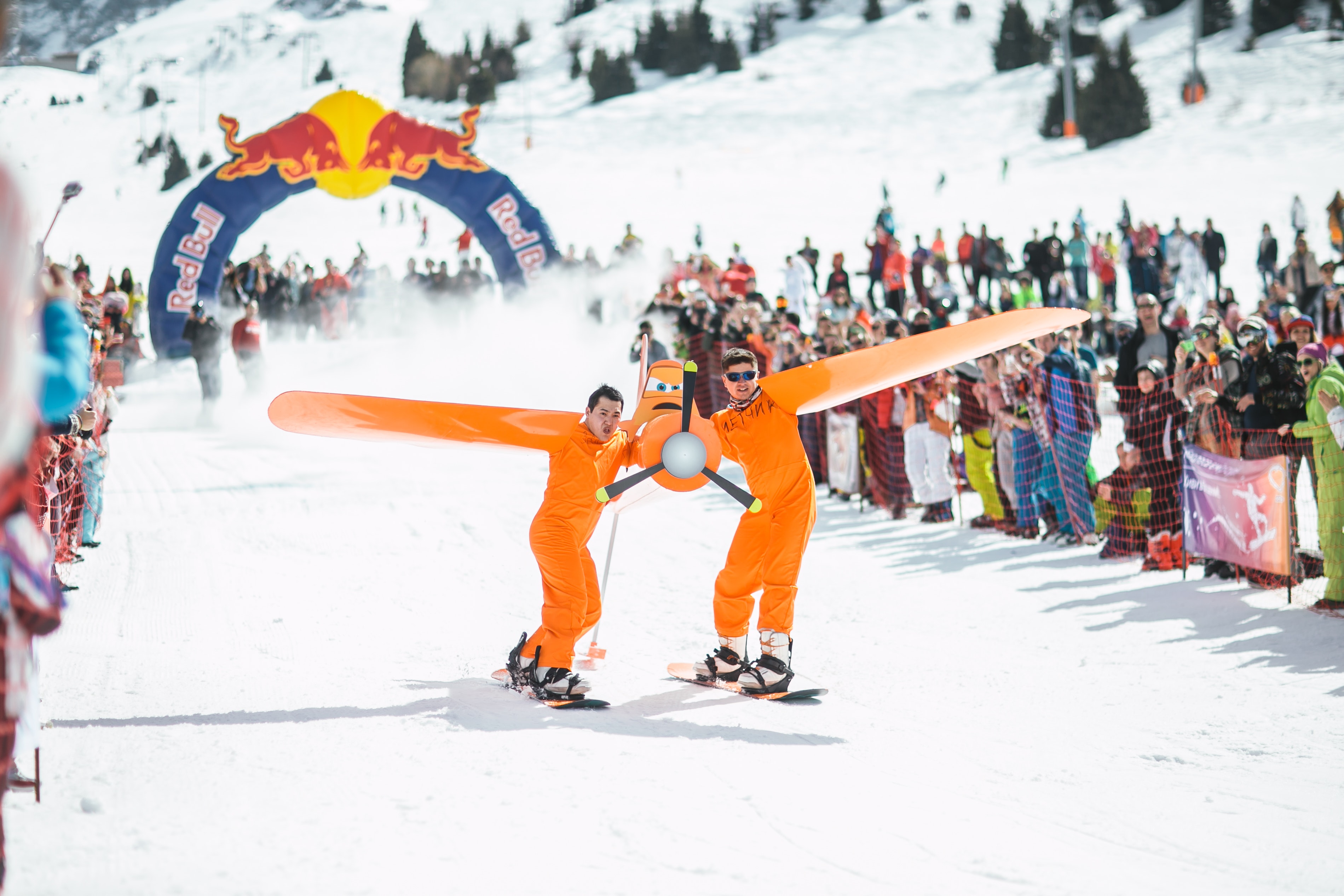 Photography of men in orange suits ridding snowboard