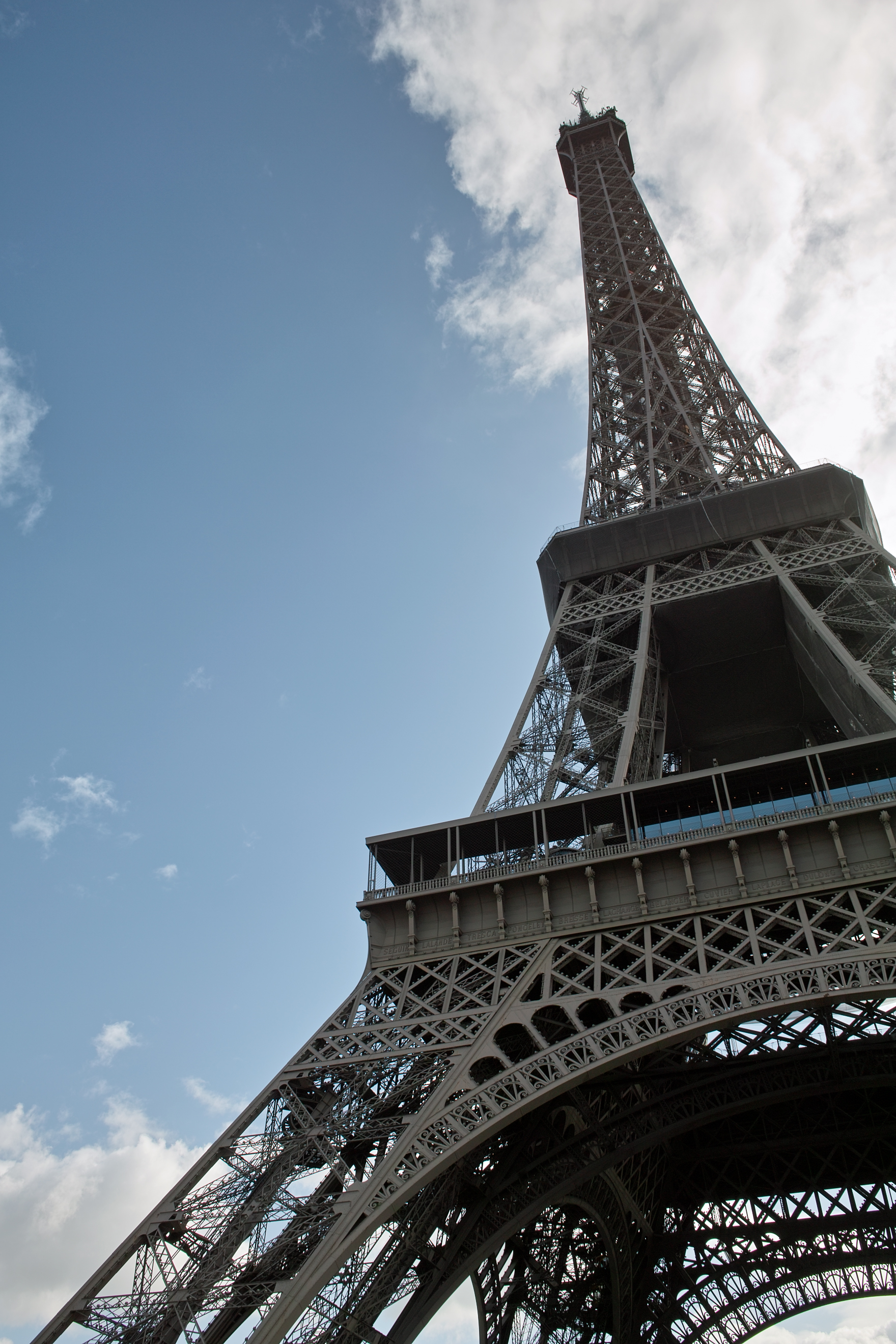 Looking up at the Eiffel Tower with blue sky and fluffy clouds | No ...