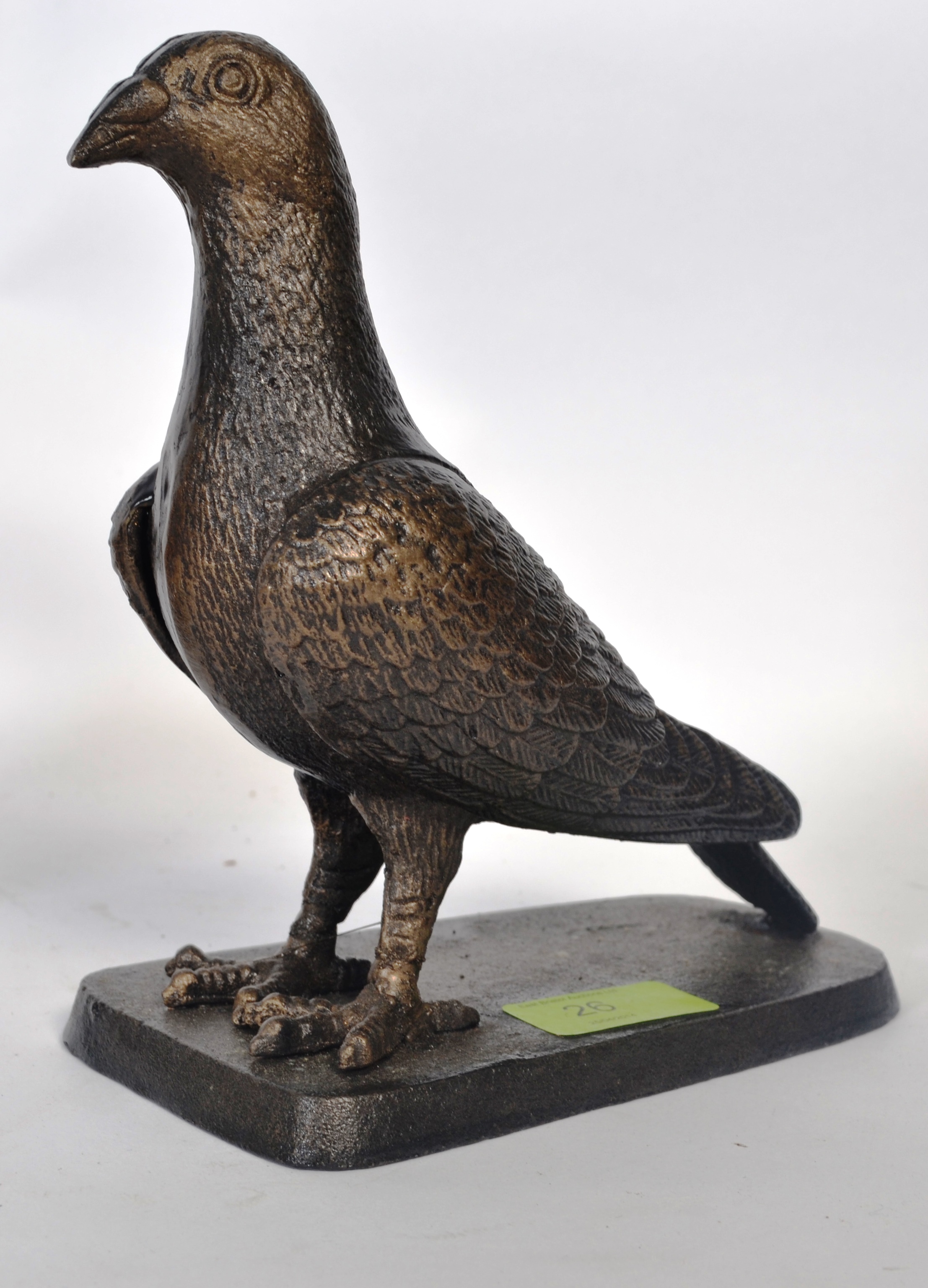 A bronze effect cast metal statue of a pigeon, on a plinth base ...