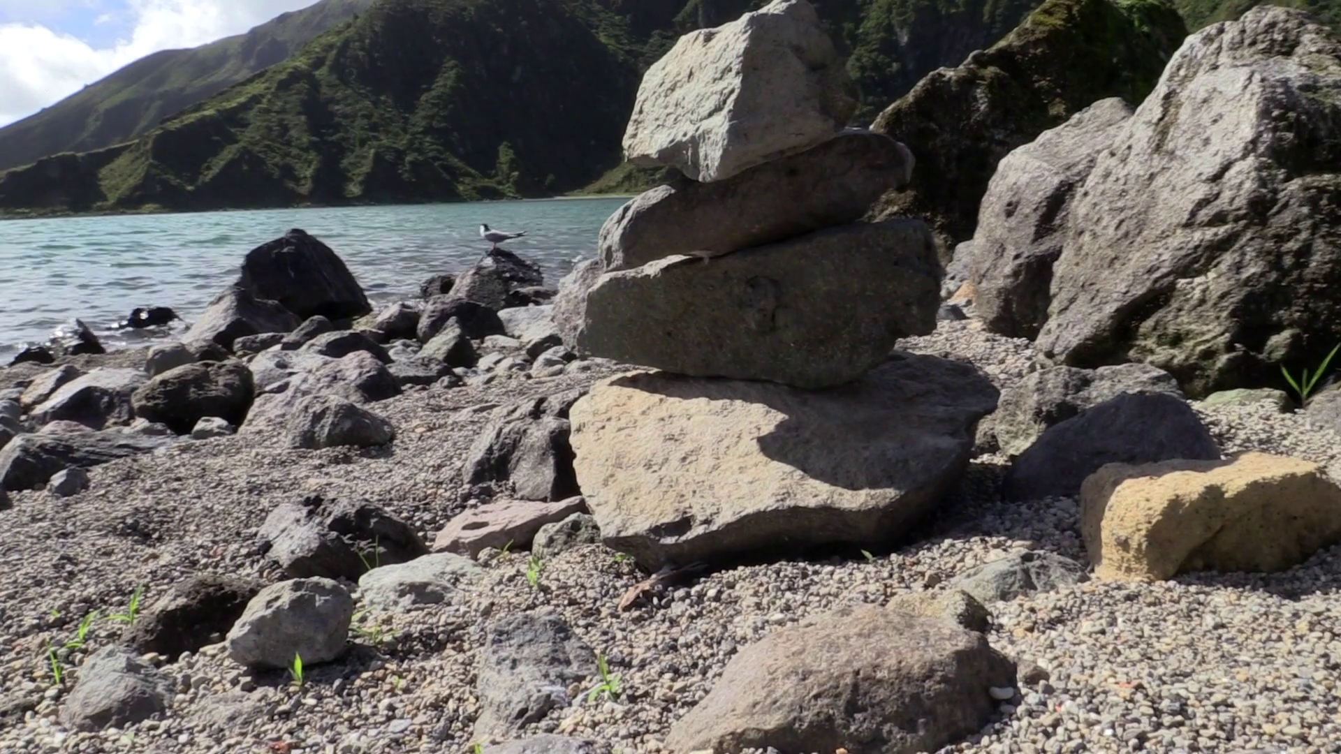 Circulating close up shot of a pile of rocks at magnificent lake ...