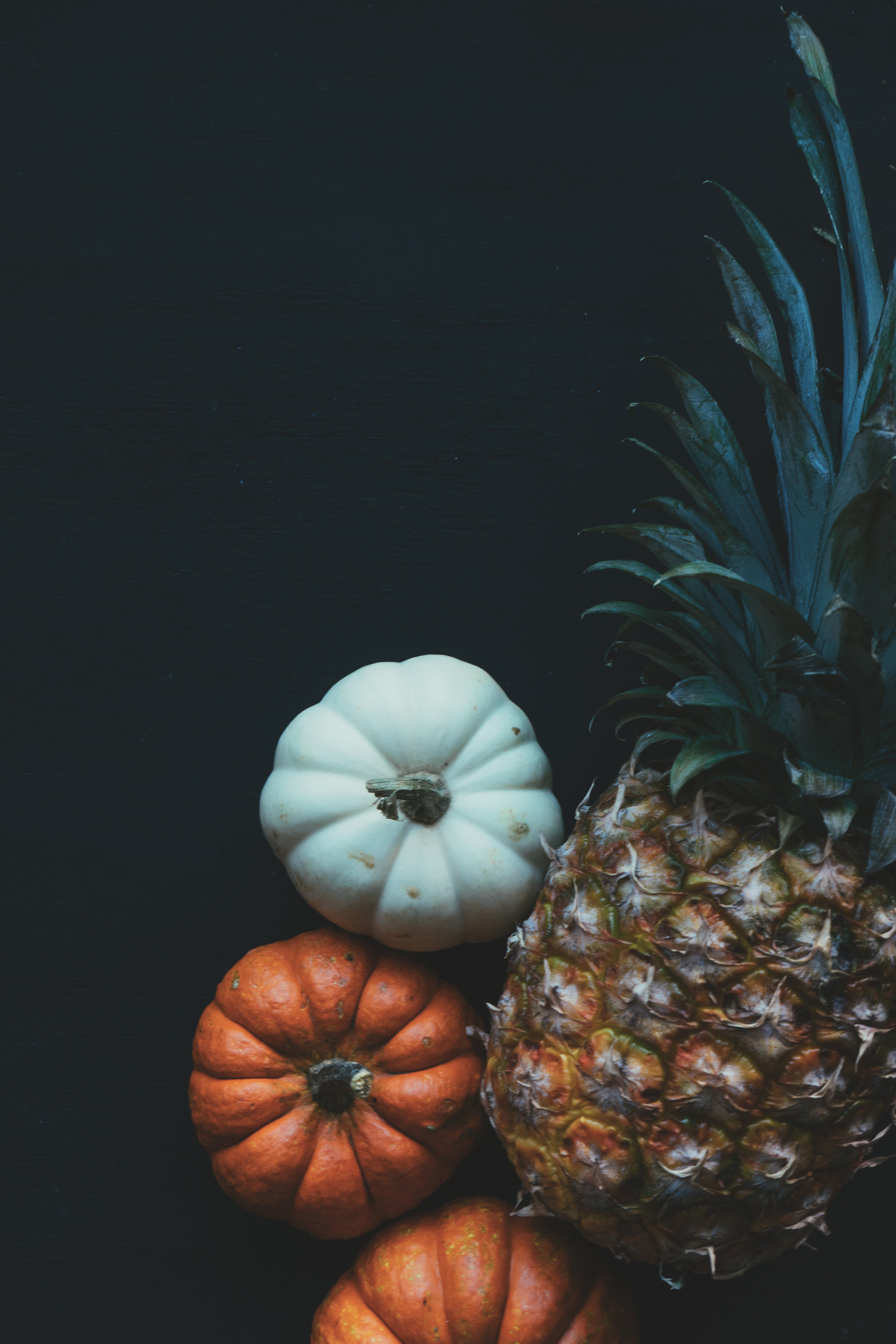 Pineapple beside pumpkin photo