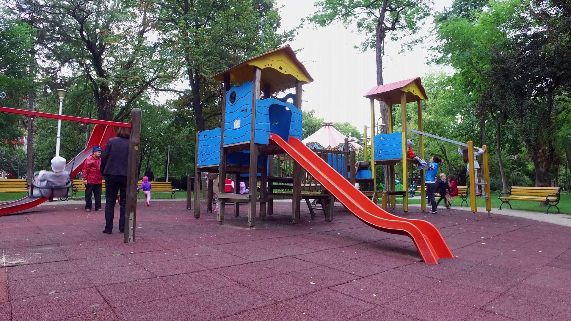 Children's playground with slide swings and merry-go-round in a park ...