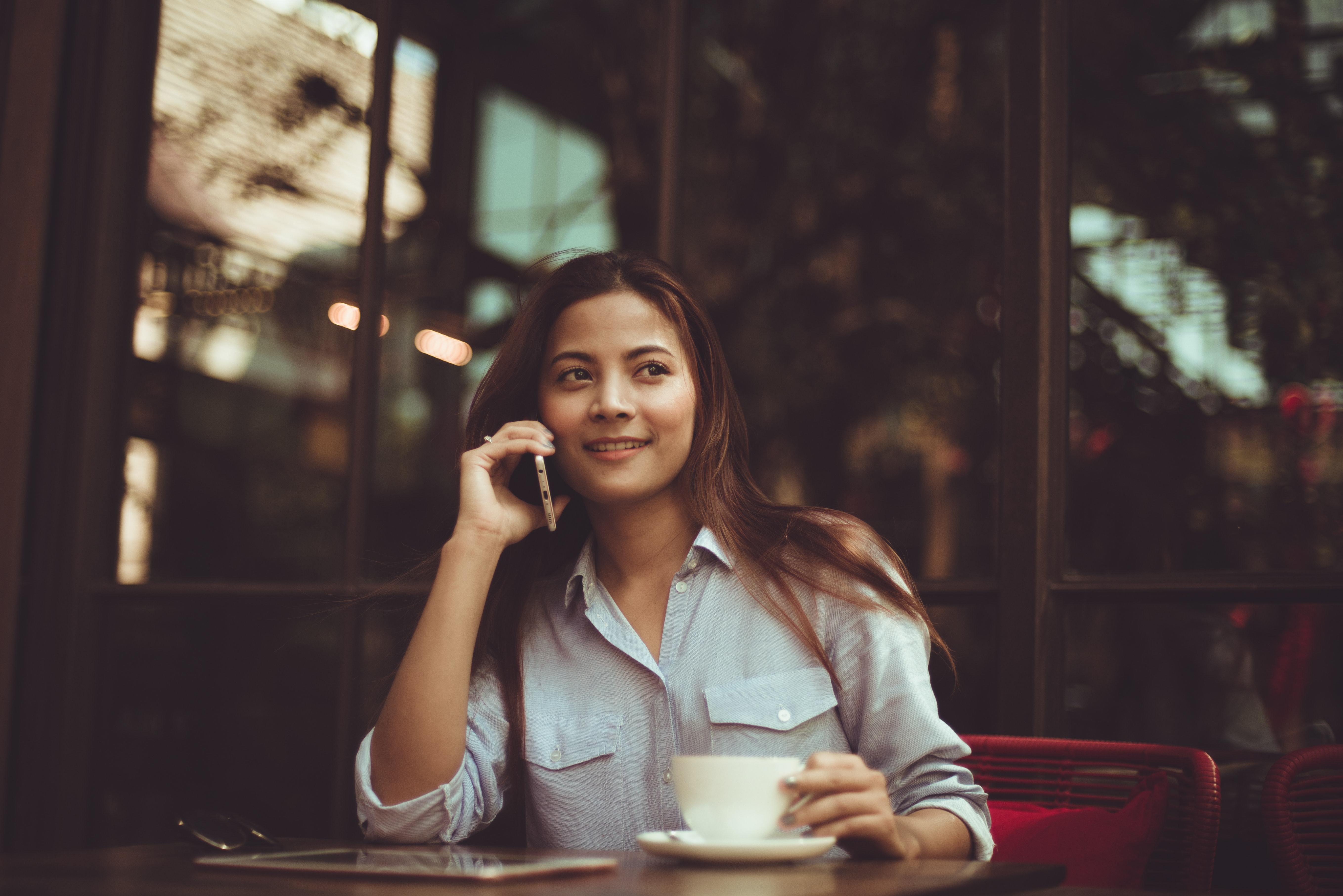 Portrait of young woman using mobile phone in cafe photo