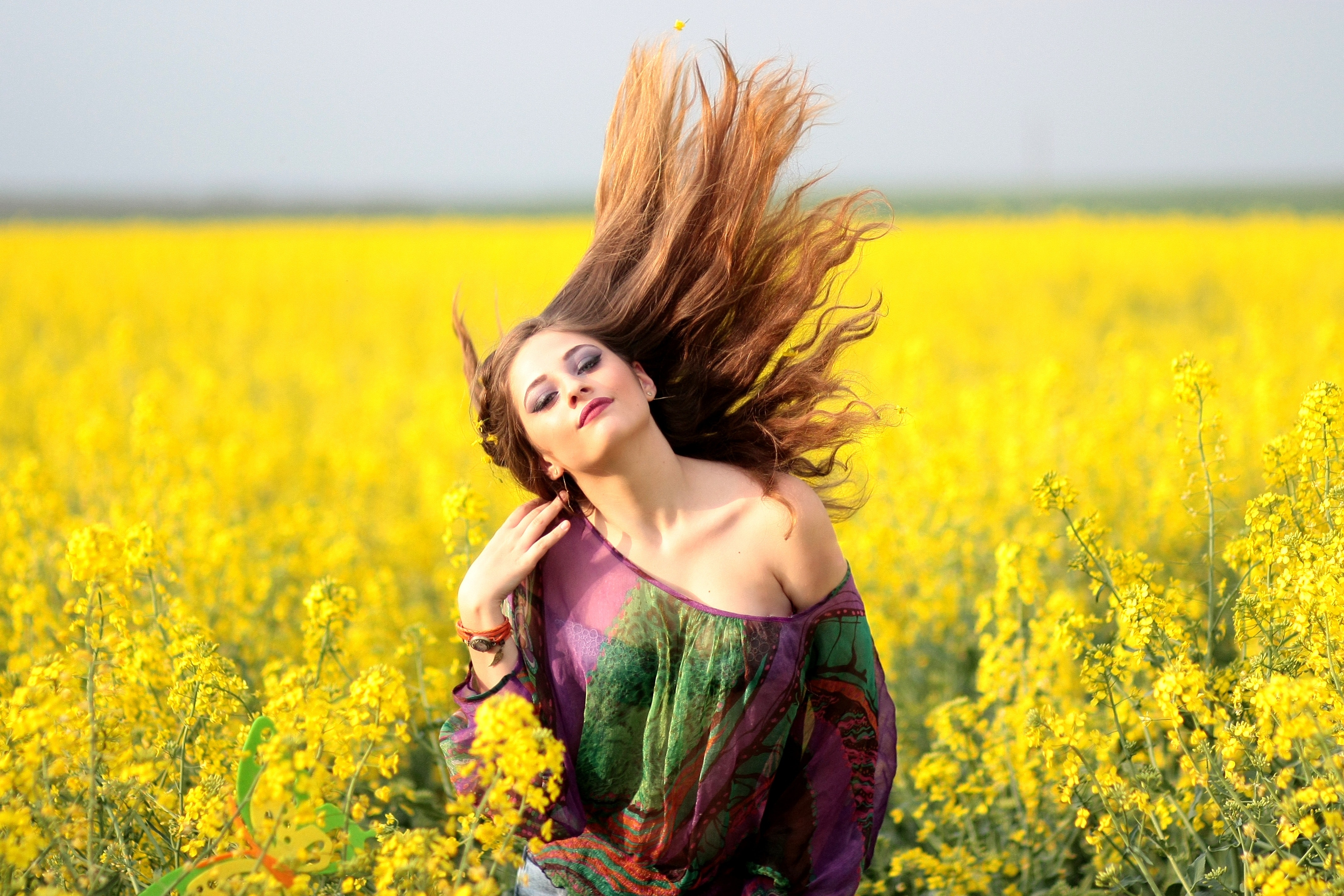 Portrait of young woman with yellow flowers in field photo