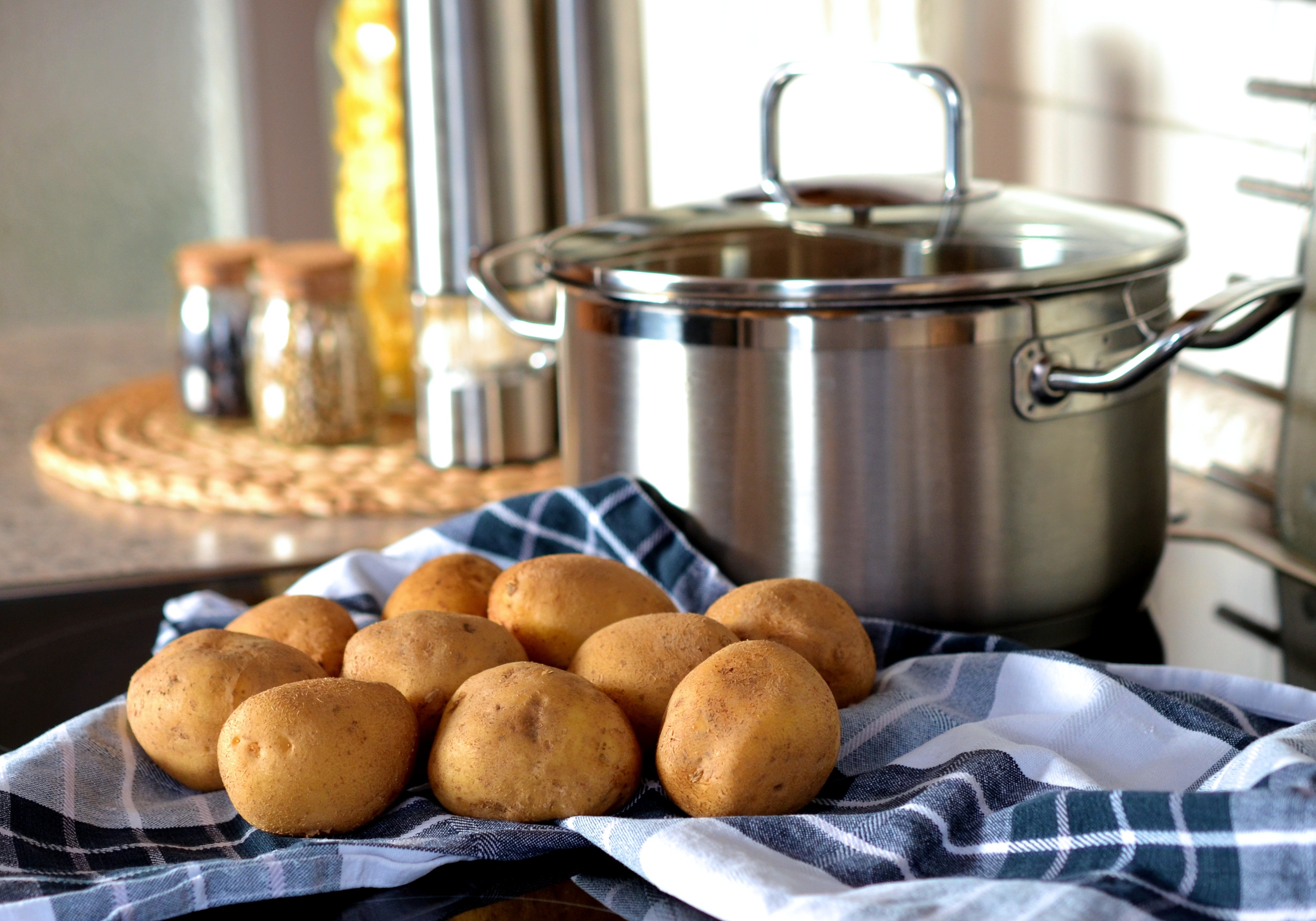 Potatoes beside stainless steel cooking pot photo