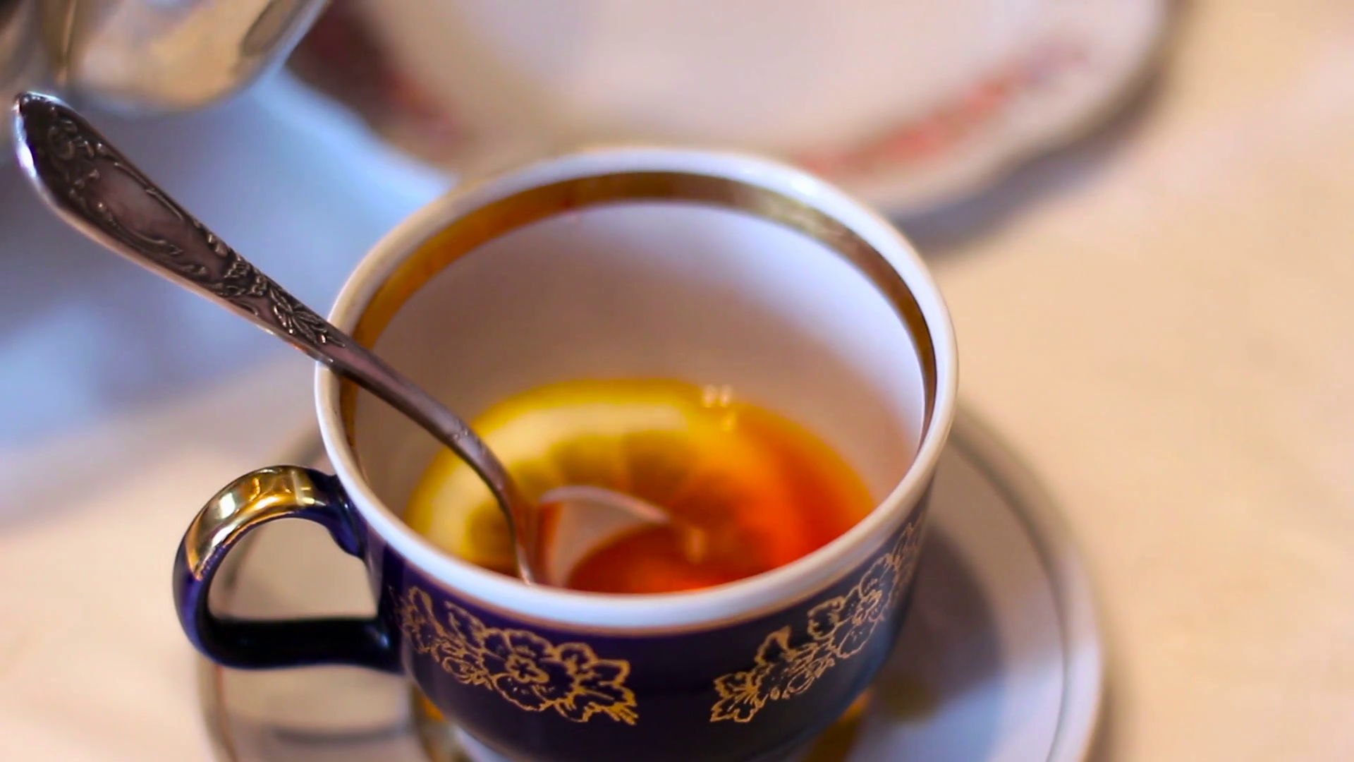 Tea with lemon. Pour the tea into the cup. Teapot and Tea Cup on the ...