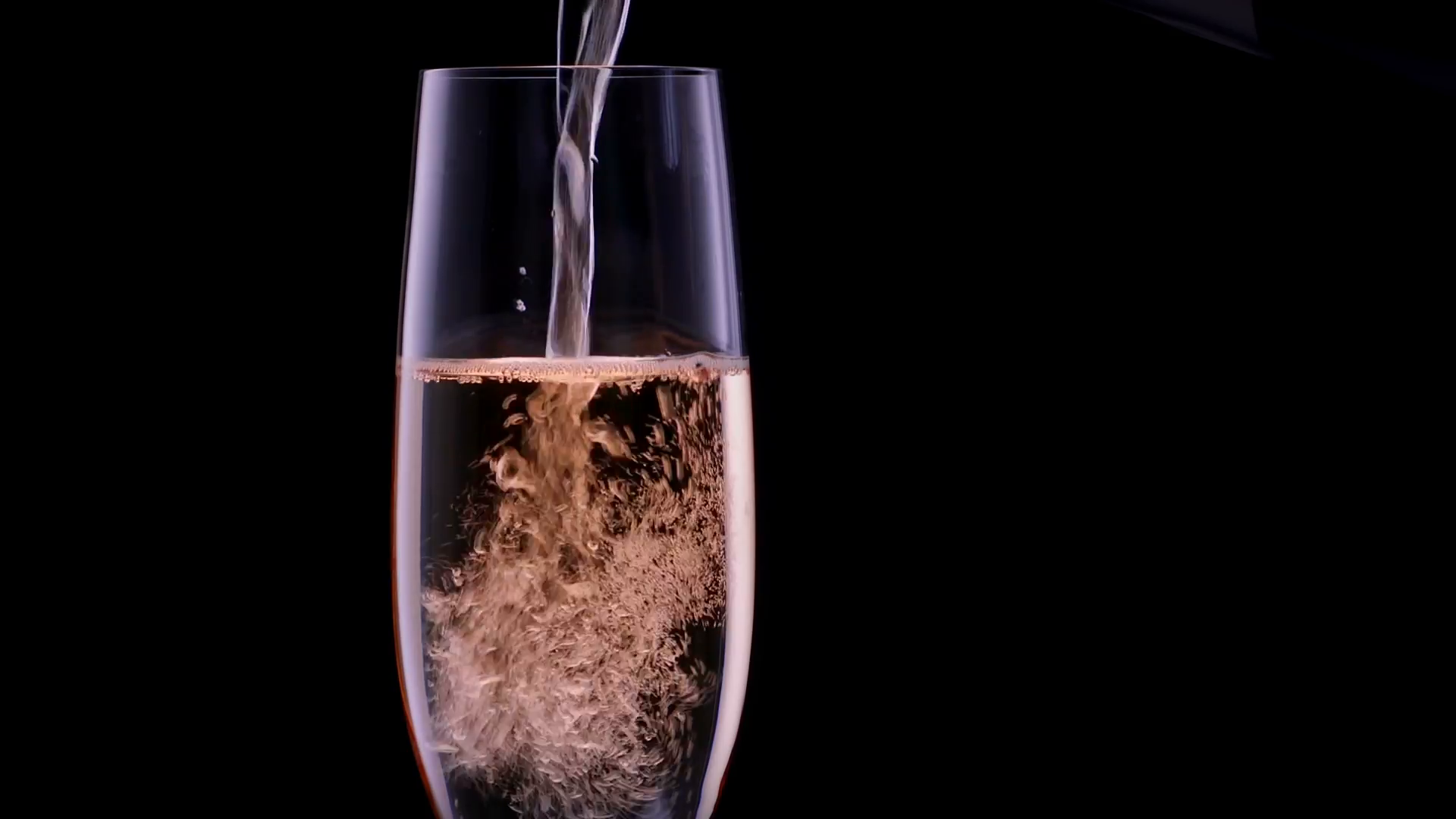Pouring champagne in a glass - with bubbles / Slow-motion studio ...