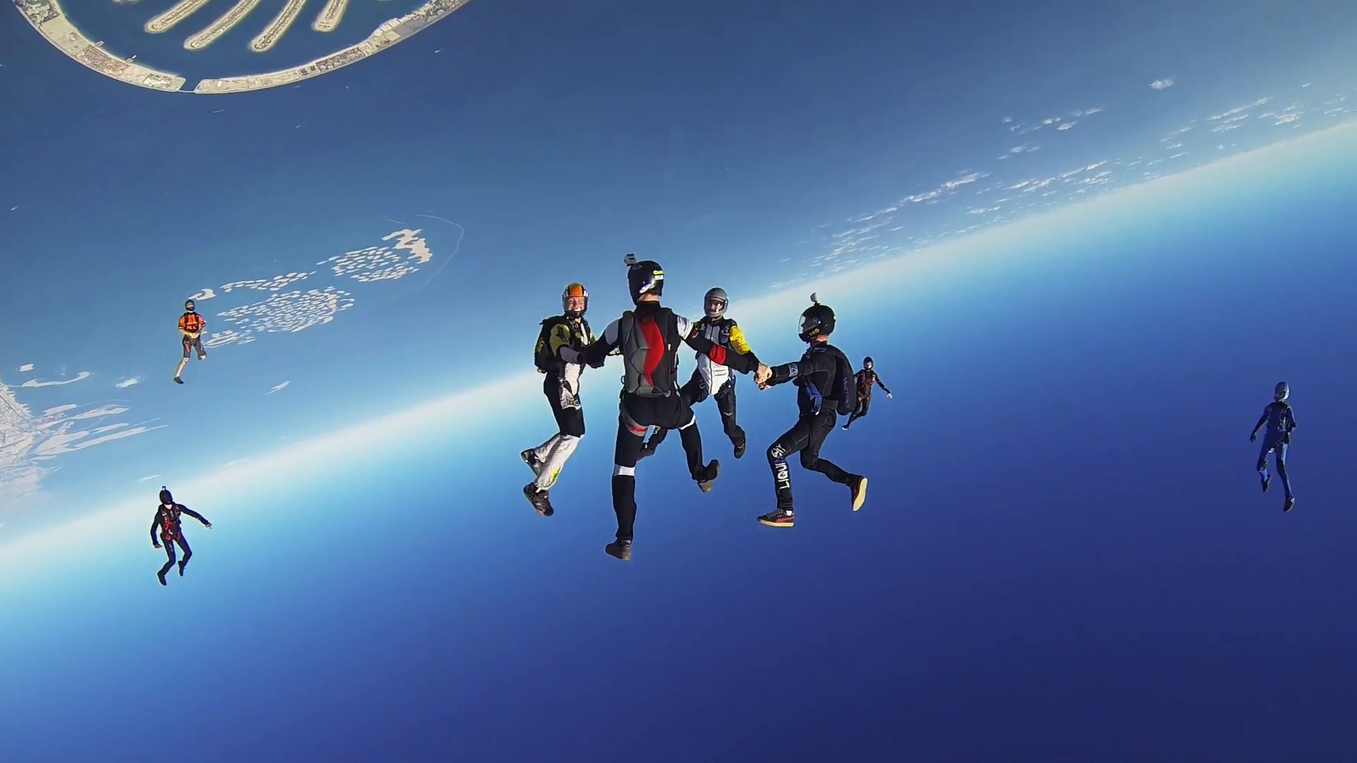 Professional skydivers parachuting above Dubai, make formation in ...
