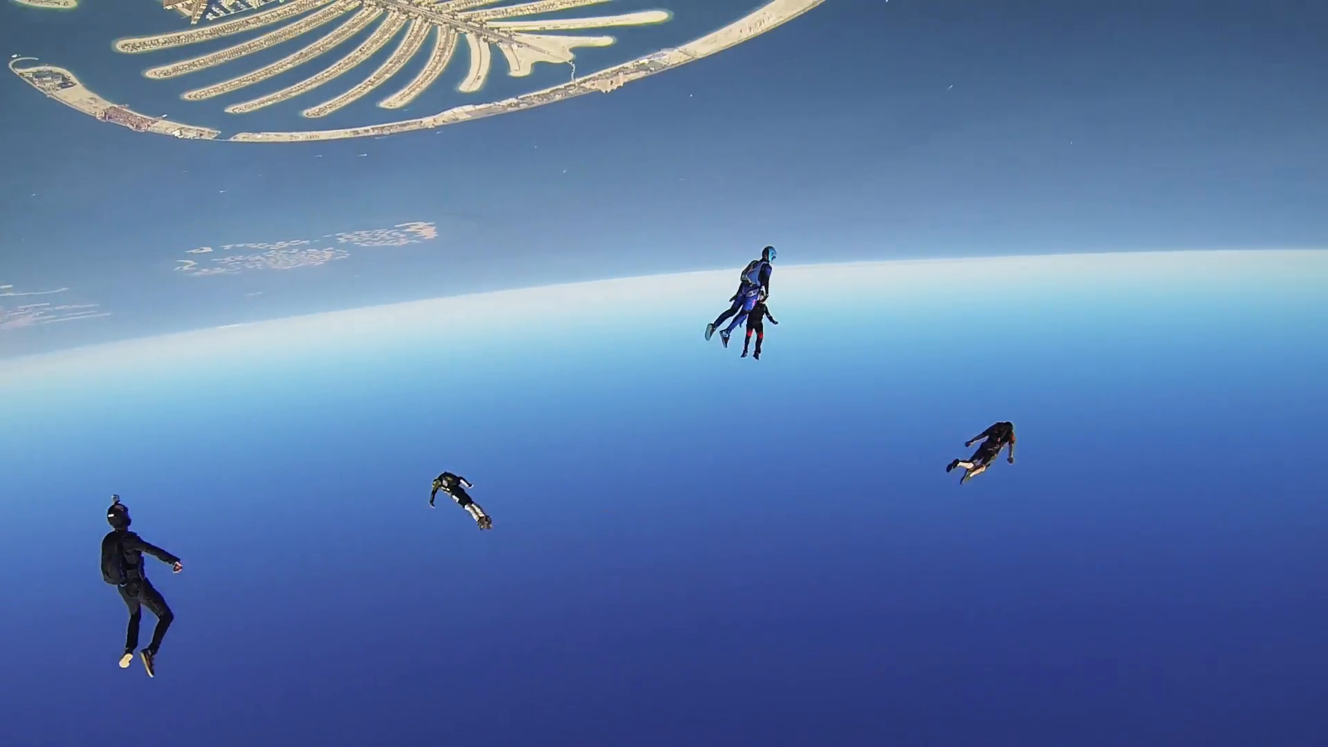 Professional skydivers parachuting above coast of Dubai. Extreme ...