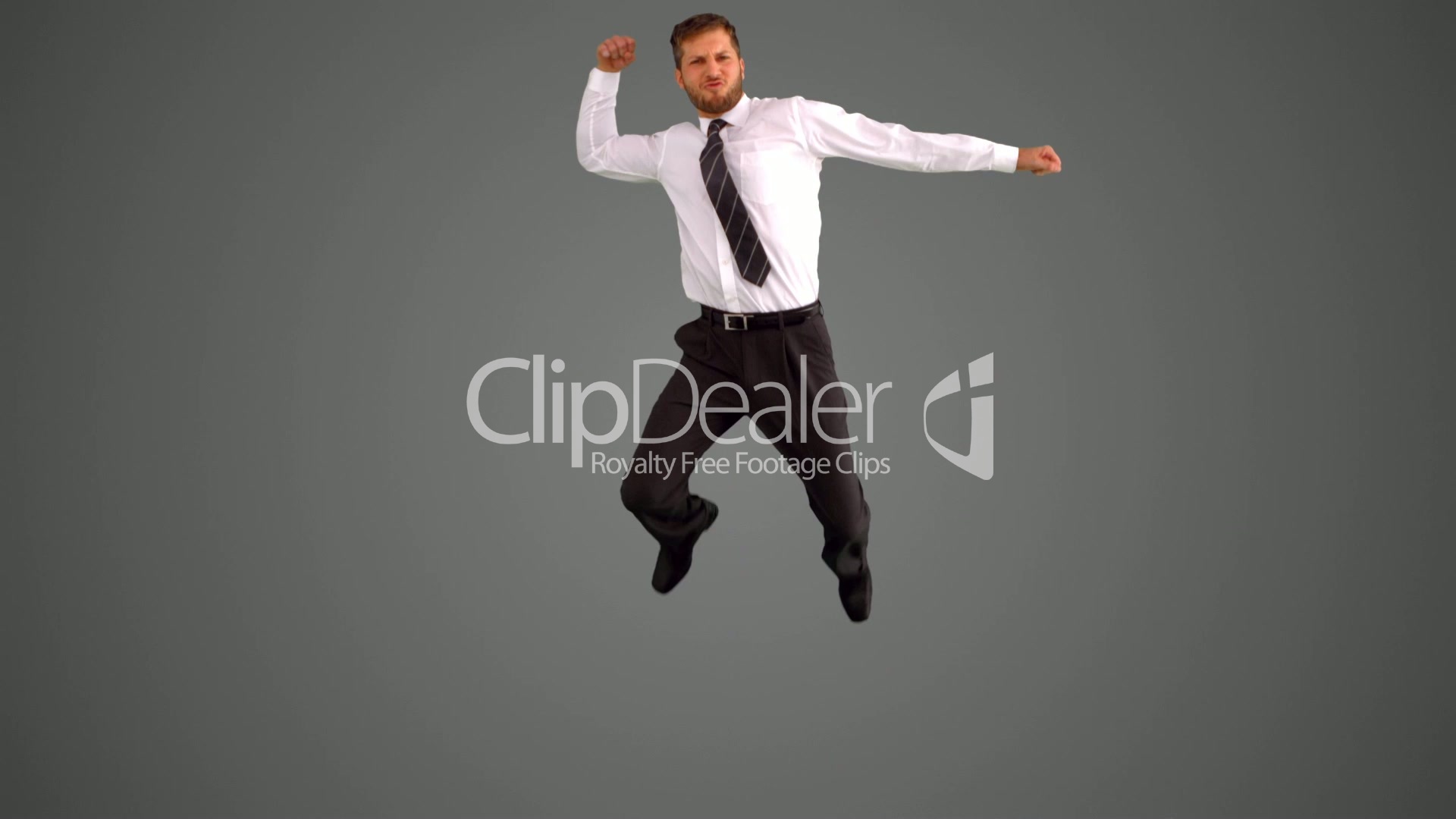 Businessman jumping and punching air on grey background: Royalty ...