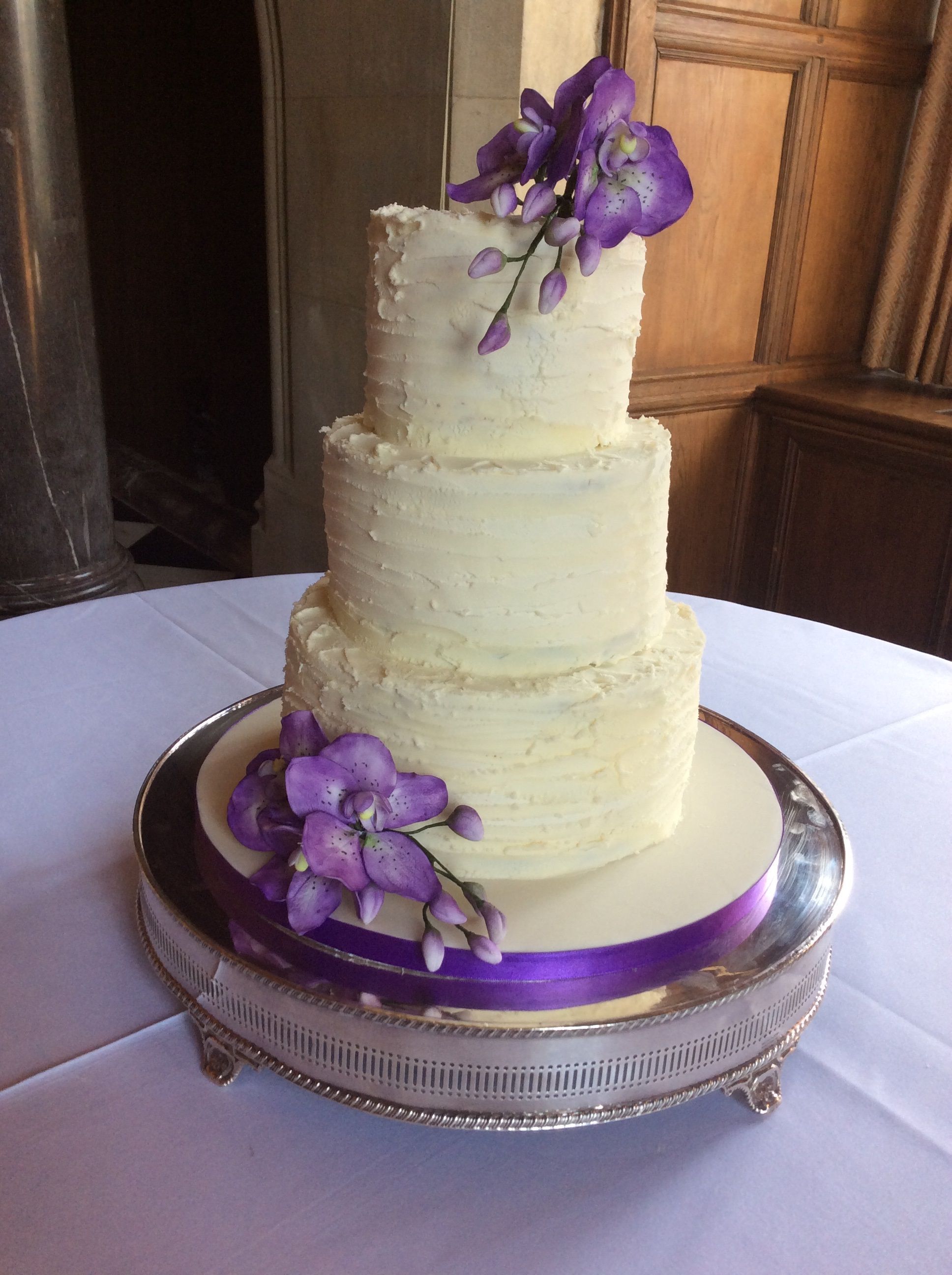 3 tier Buttercream covered cake with textured finish and sprays of ...