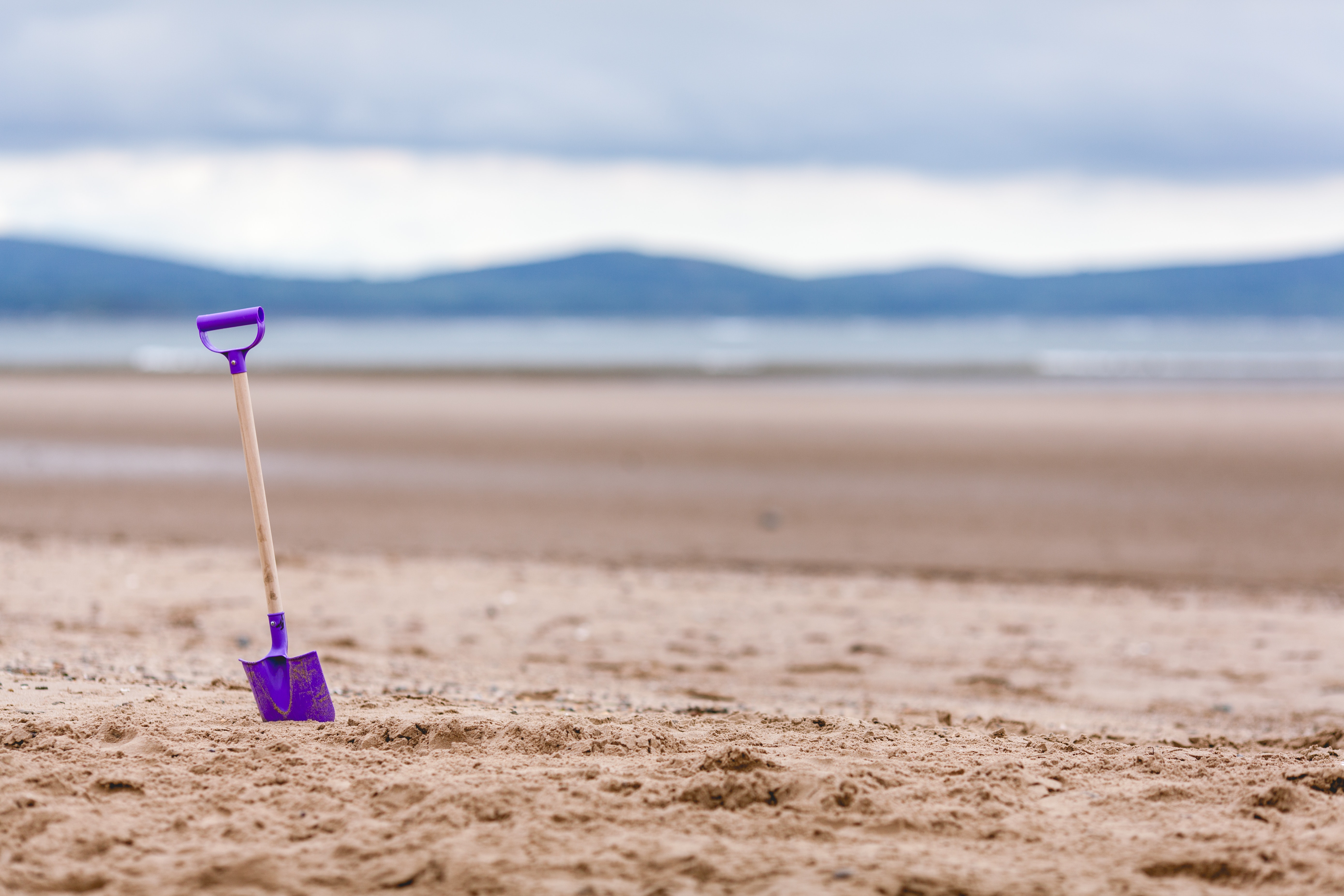Purple shovel on sand bottom focus camera photo