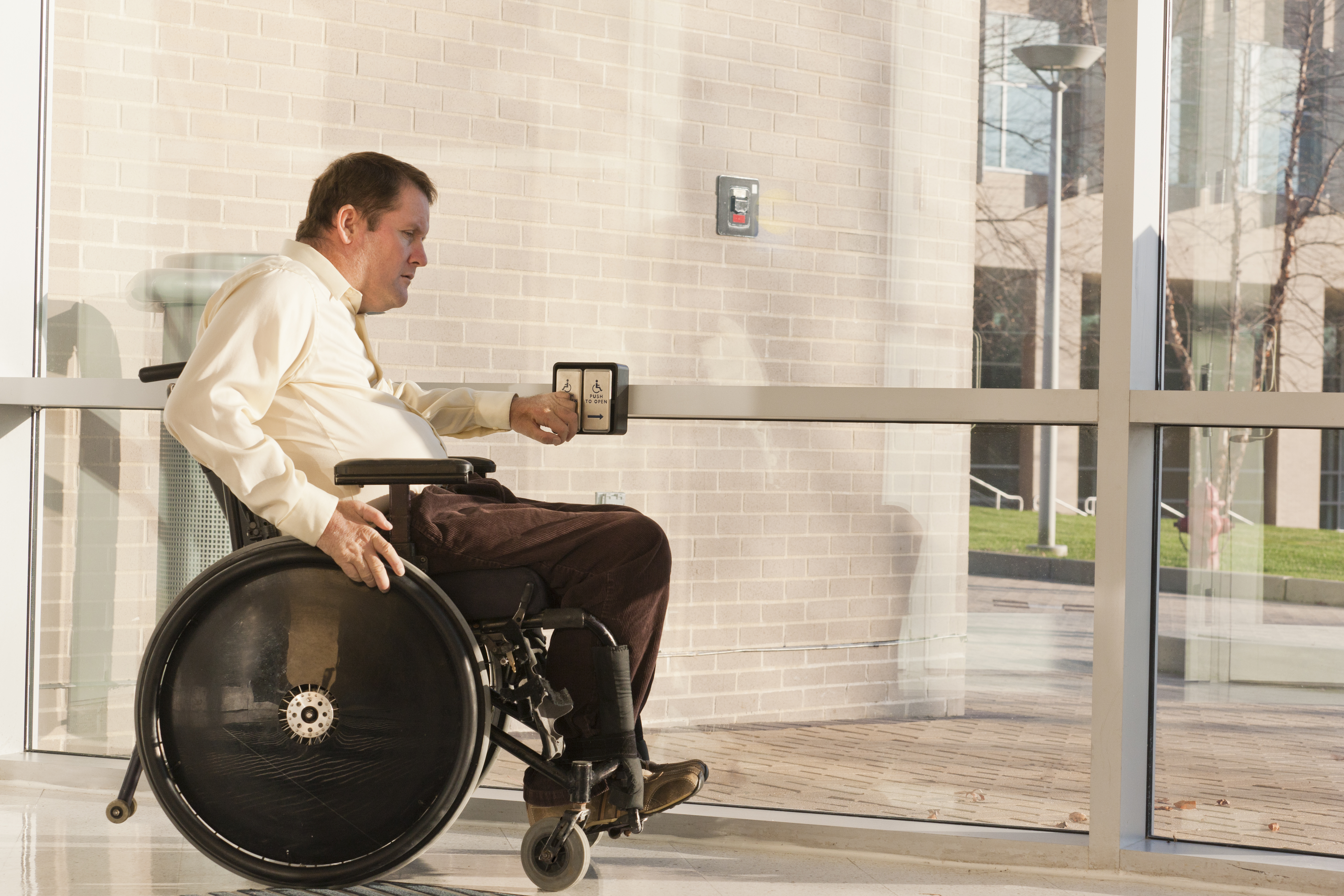 business man in wheelchair pushing button to open door 141343661 ...