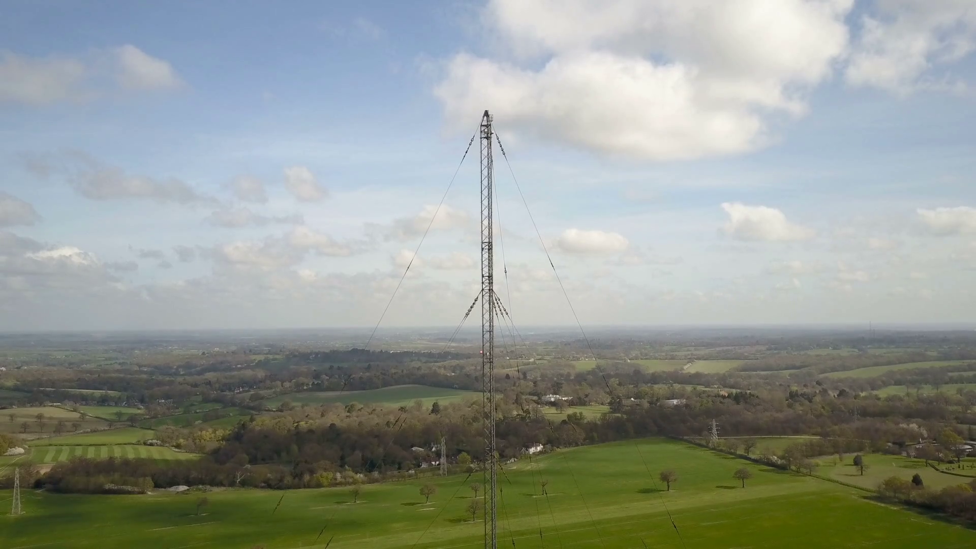 Radio mast antenna and English countryside; drone reverse and reveal ...